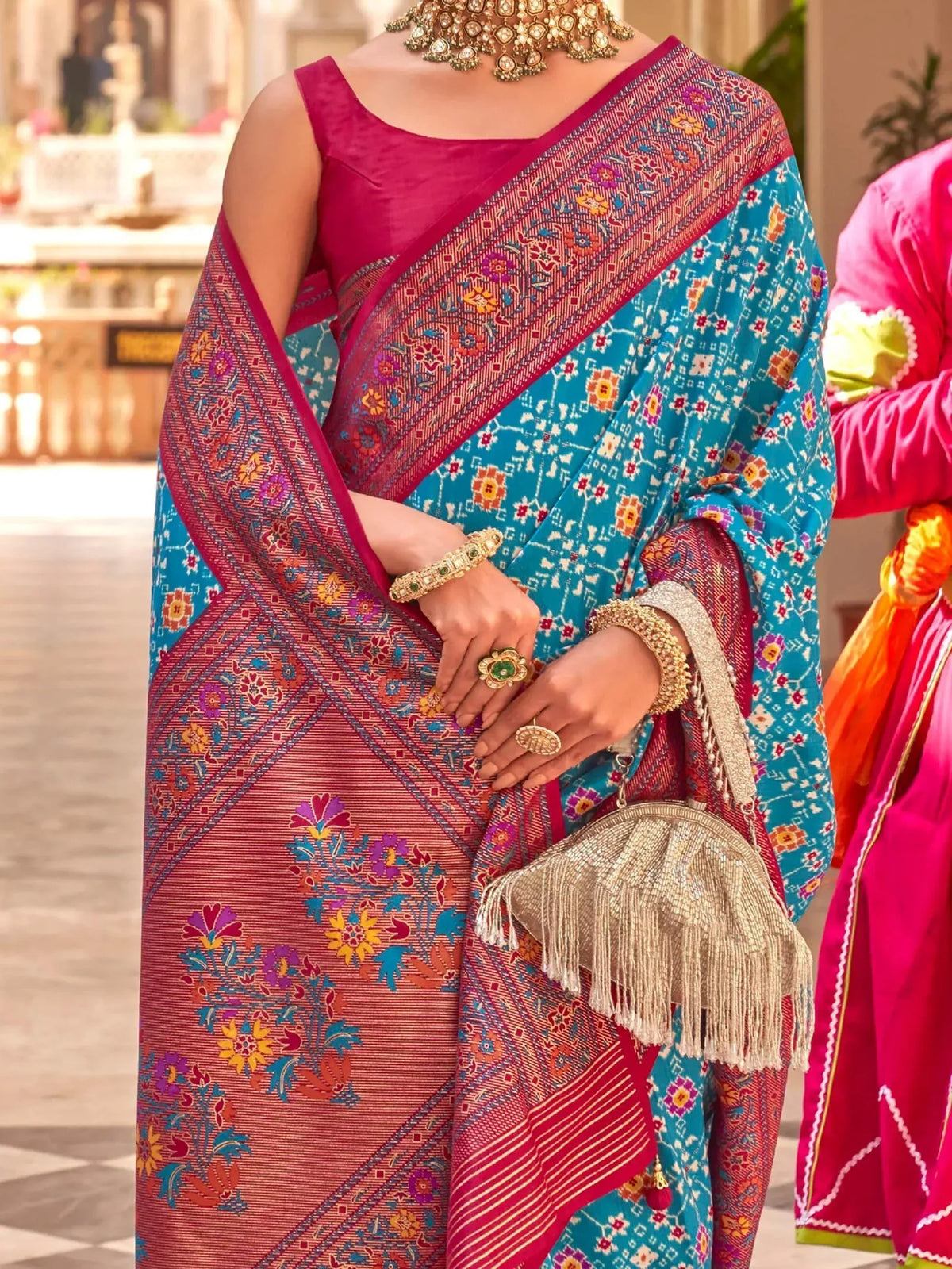 Vibrant blue and pink floral saree with gold jewelry, perfect for Indian ethnic occasions