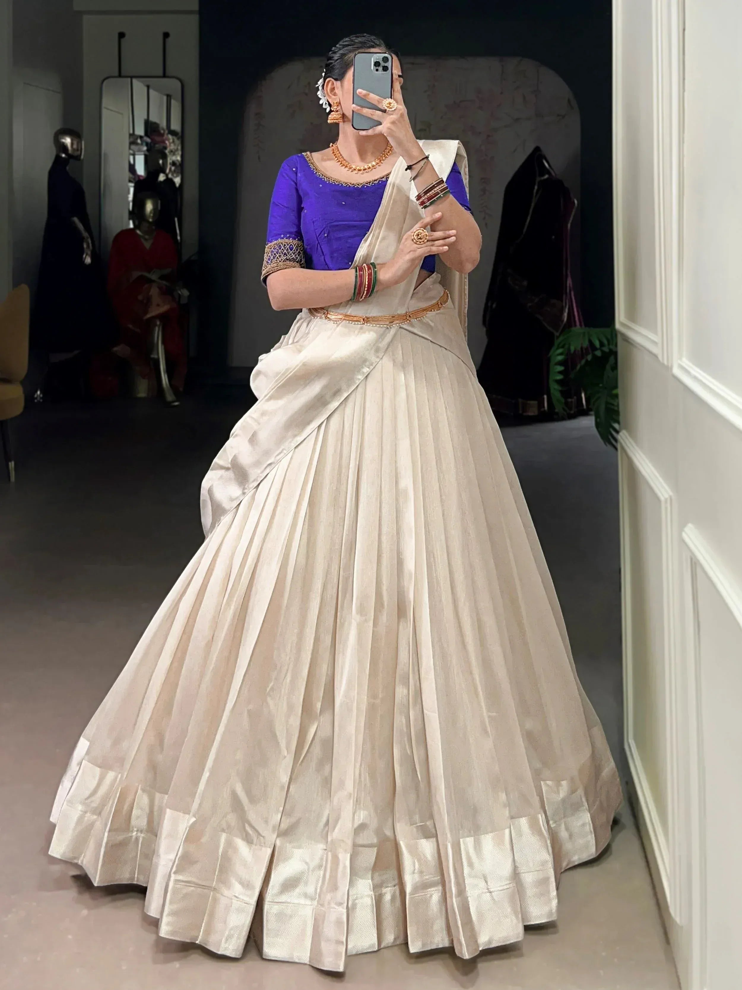 Woman in cream pleated lehenga with purple blouse, ethnic Indian wear for weddings or festivals
