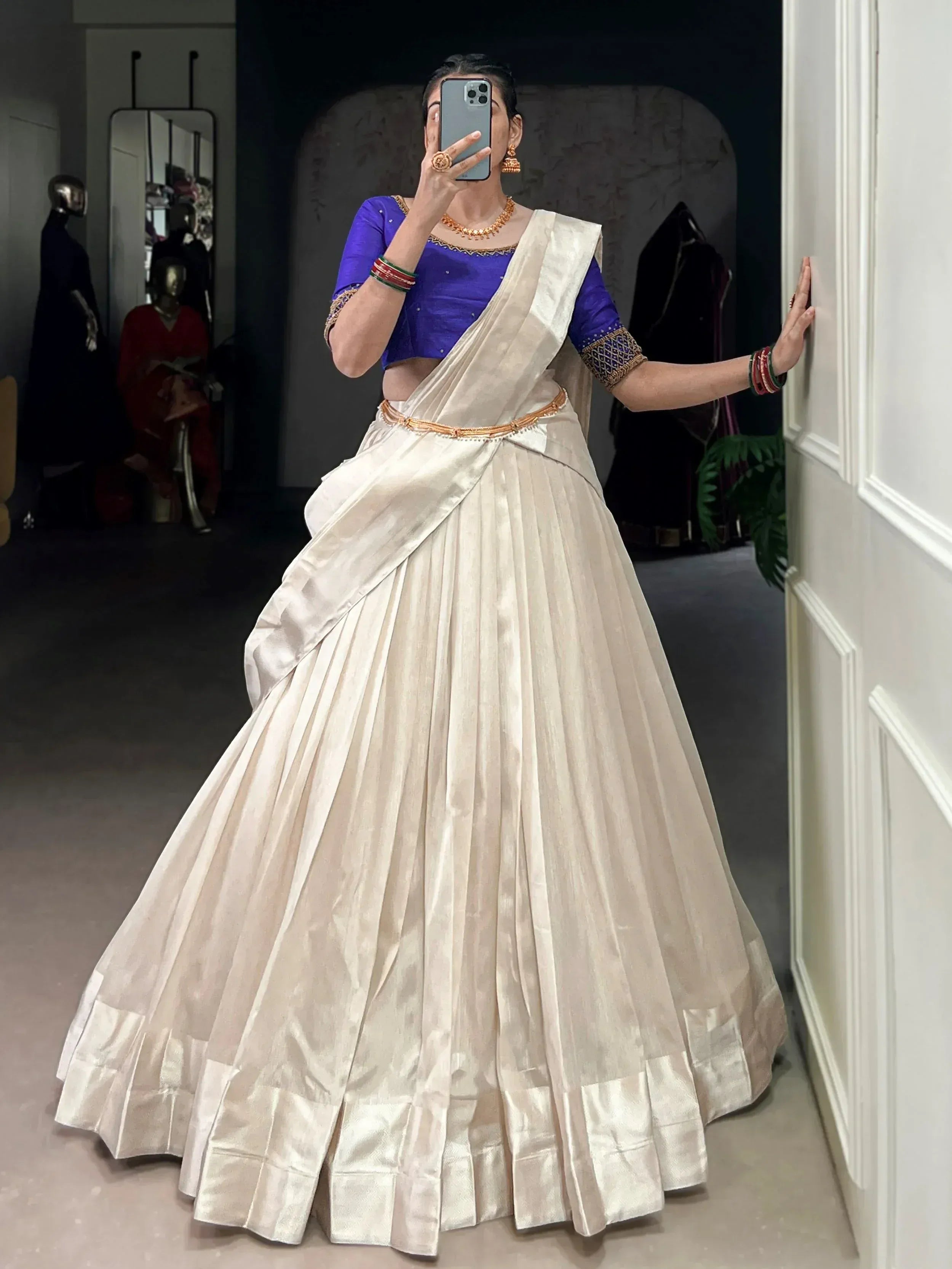 Woman in cream pleated lehenga with blue blouse, ethnic Indian wear for weddings or festivals
