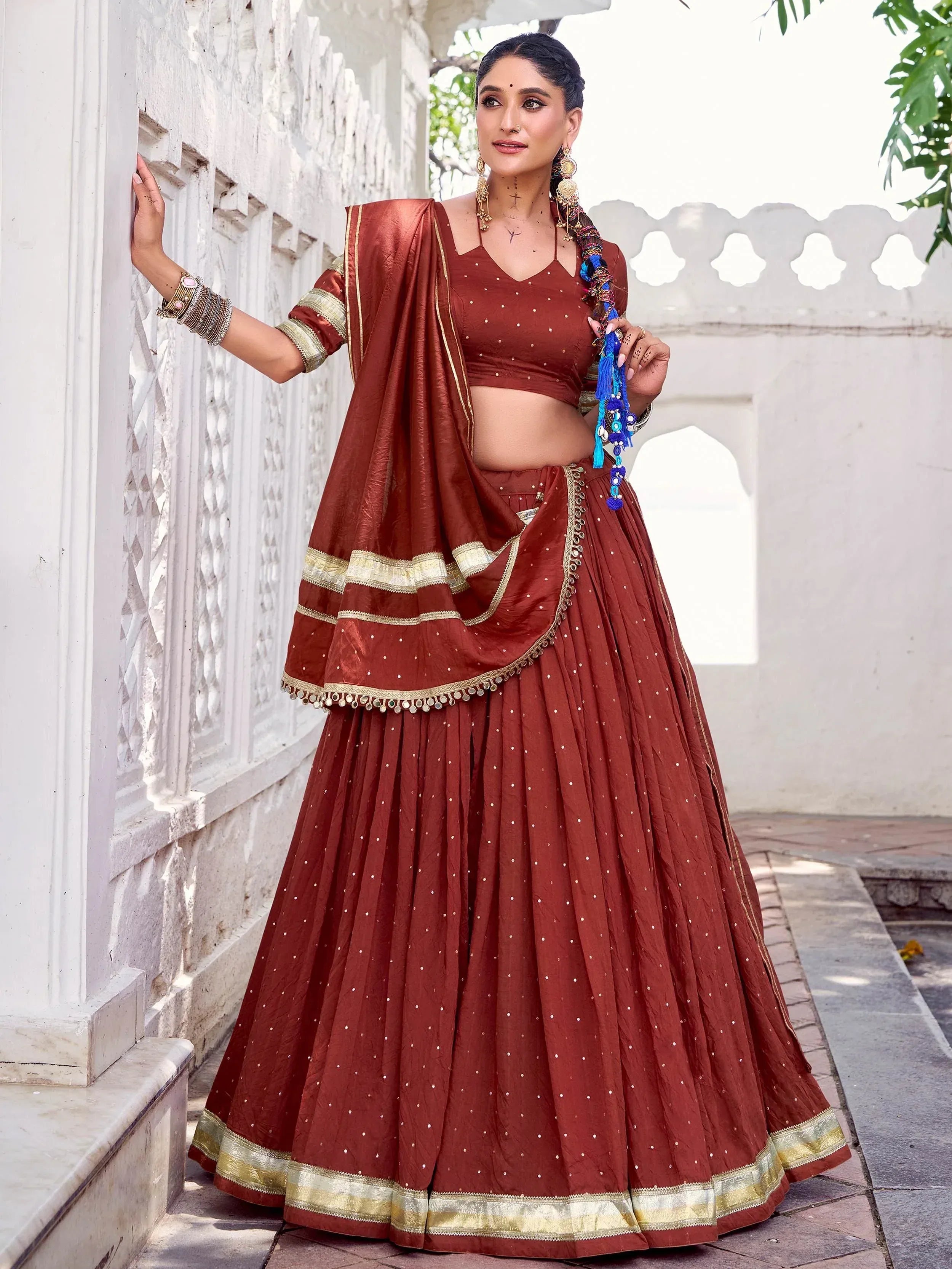 Elegant maroon lehenga choli with gold trim, perfect for Indian ethnic wear and festive occasions.