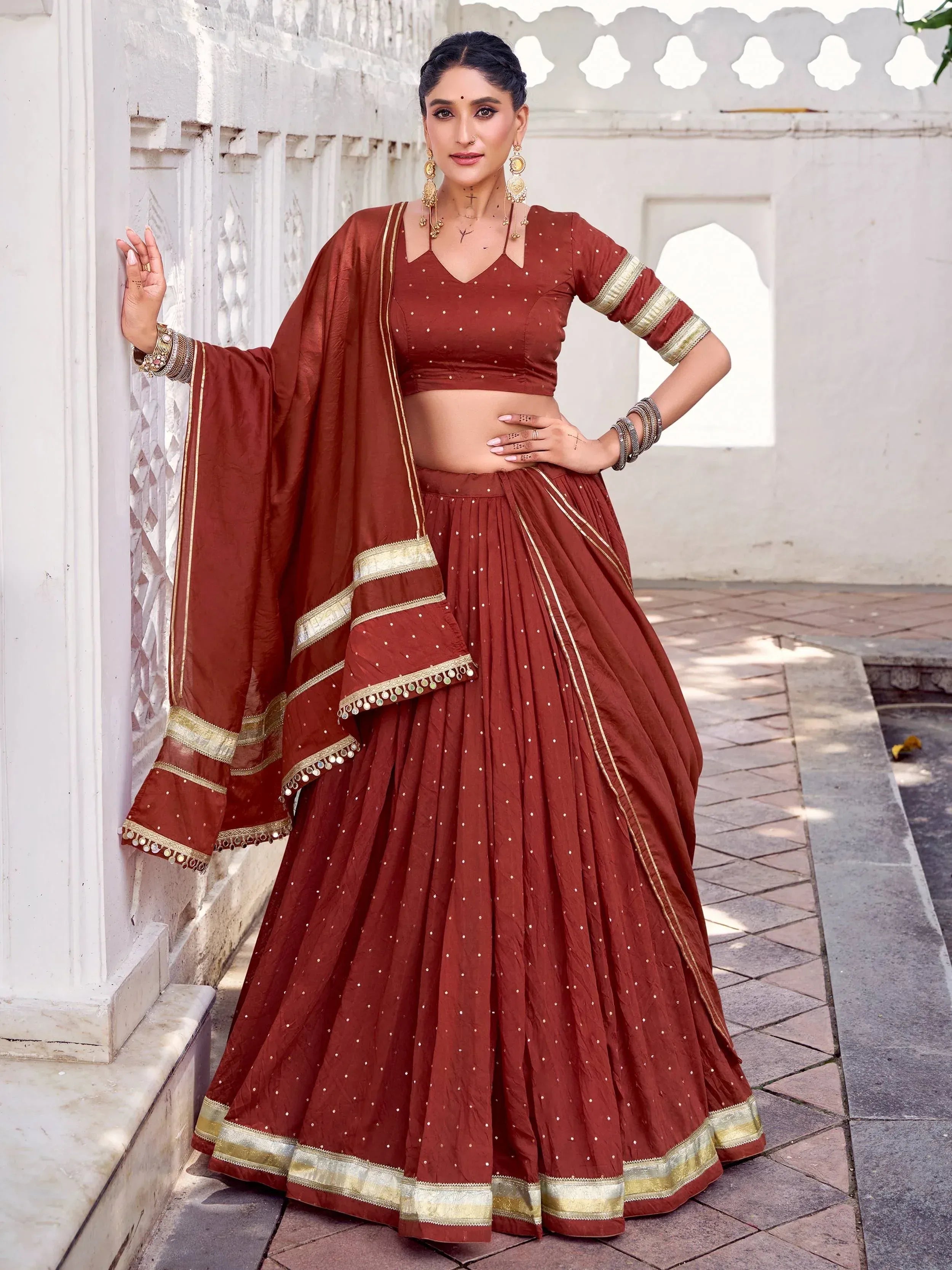 Elegant maroon lehenga choli with gold trim, perfect for Indian ethnic wear and festive occasions.