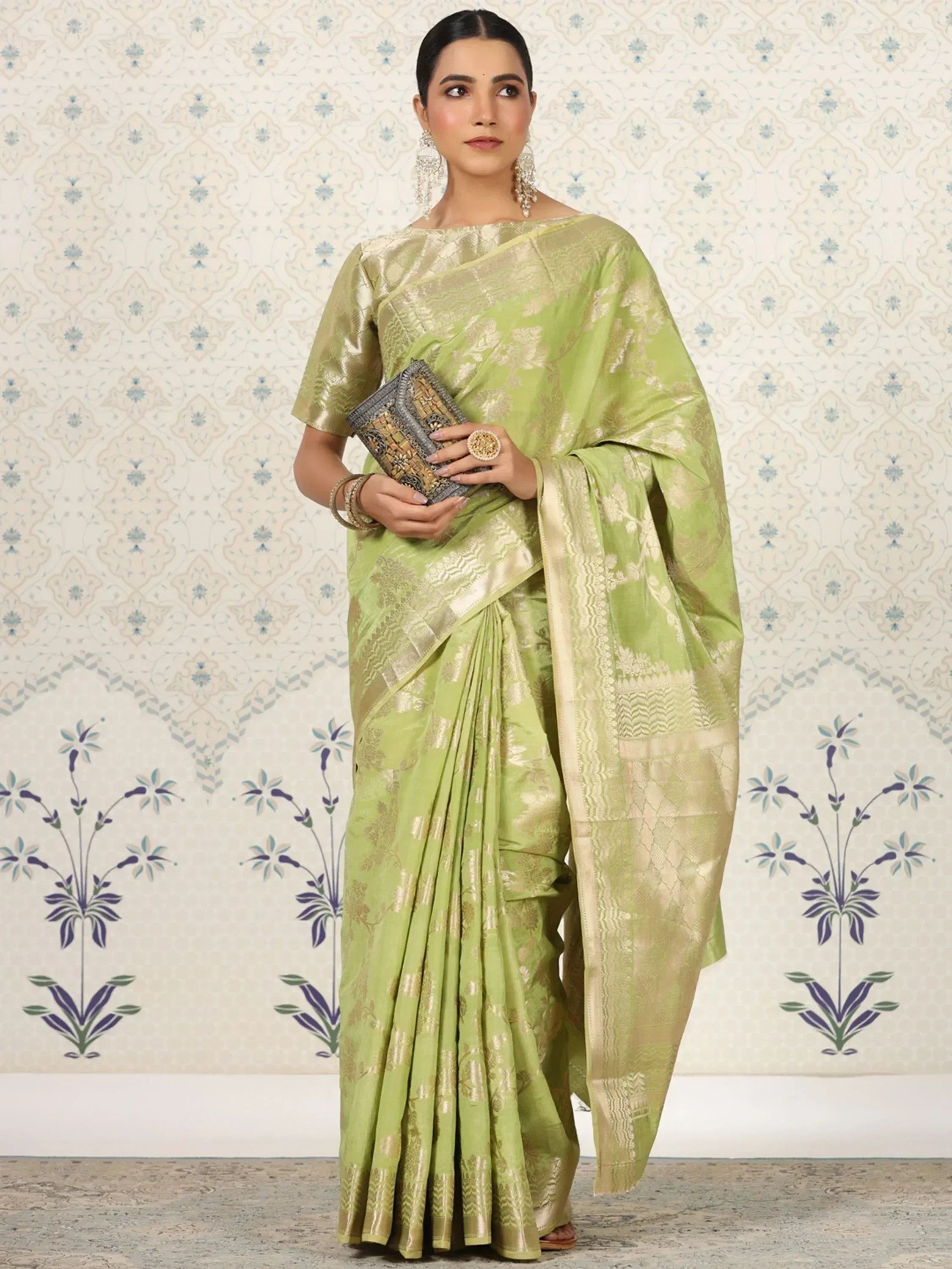 Elegant lime green saree with gold embroidery, paired with matching blouse and clutch, perfect for Indian ethnic occasions.