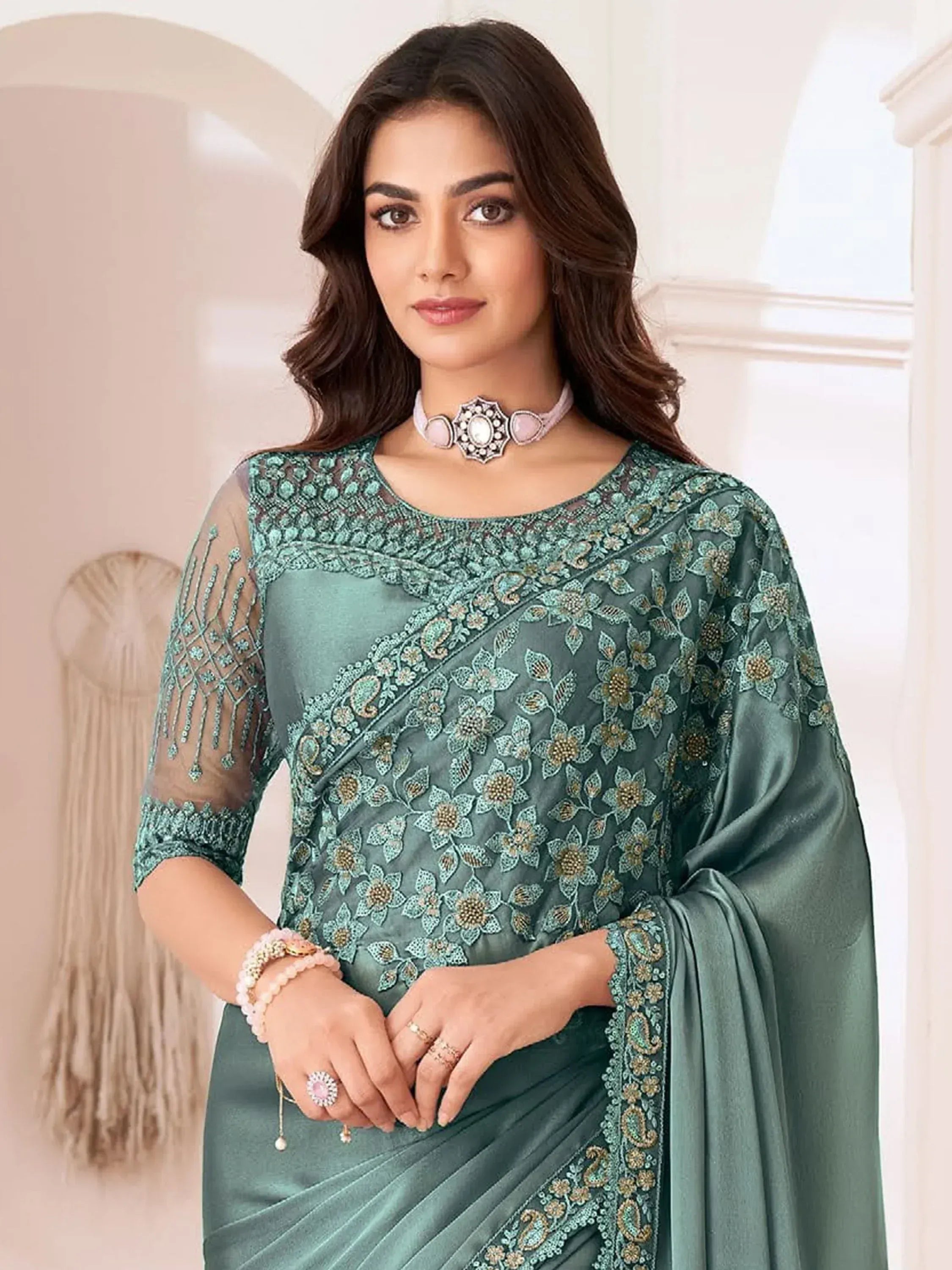 Elegant teal embroidered saree with sheer sleeves and floral detailing, perfect for Indian ethnic occasions.