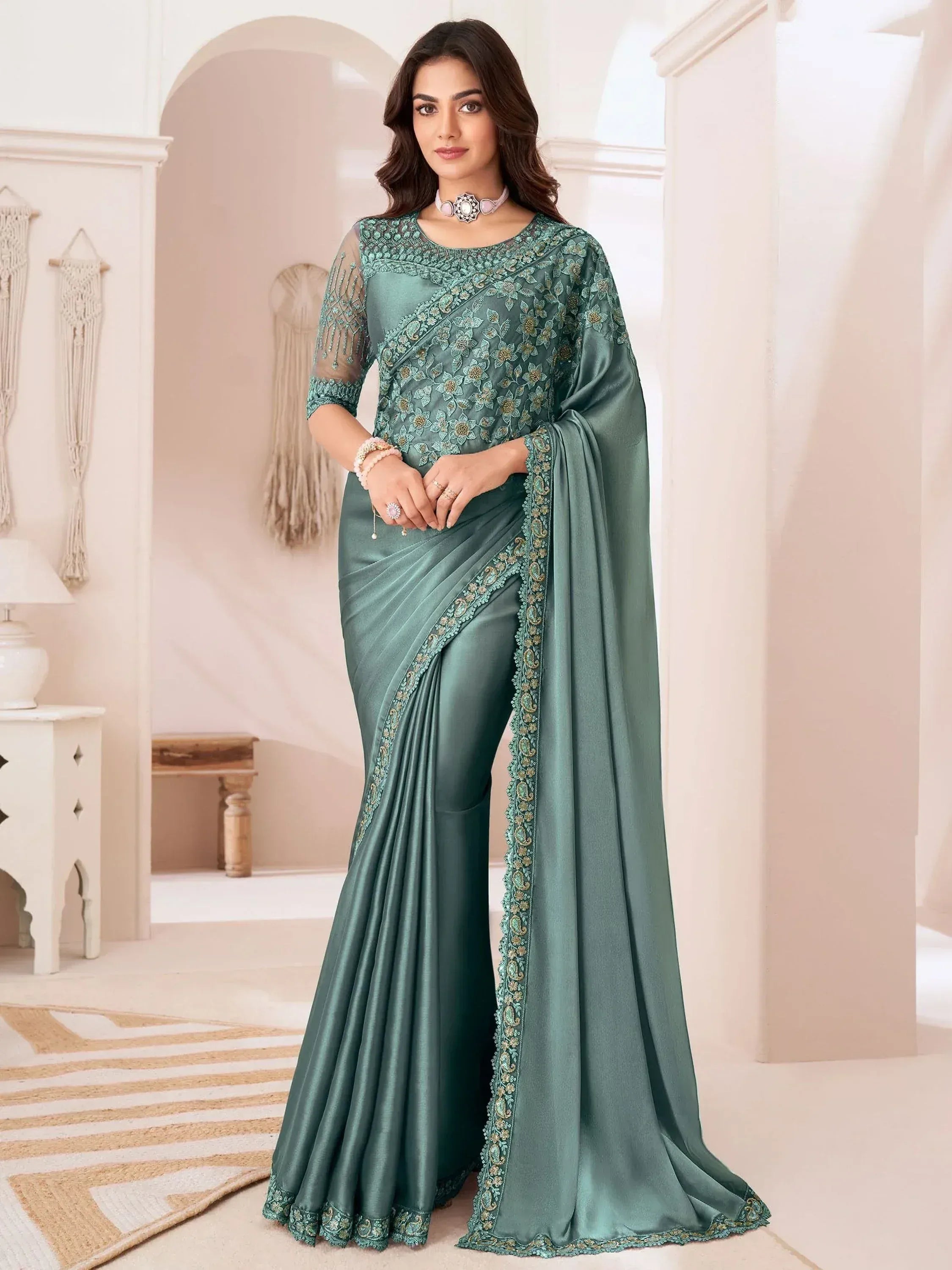 Elegant teal designer saree with floral embroidery and sheer sleeves, perfect for Indian ethnic occasions.