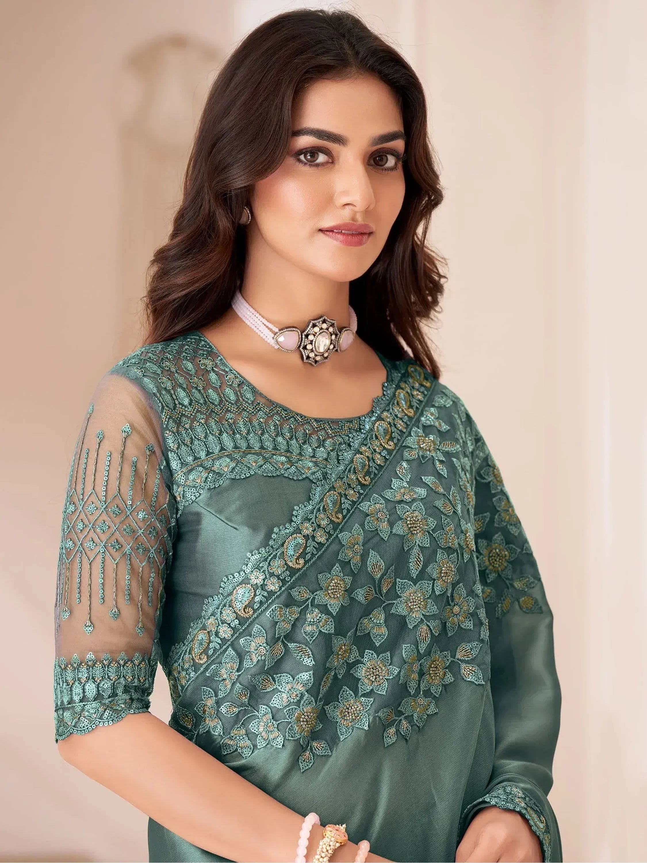 Green embroidered ethnic kurti with sheer sleeves and floral detailing, paired with statement choker necklace