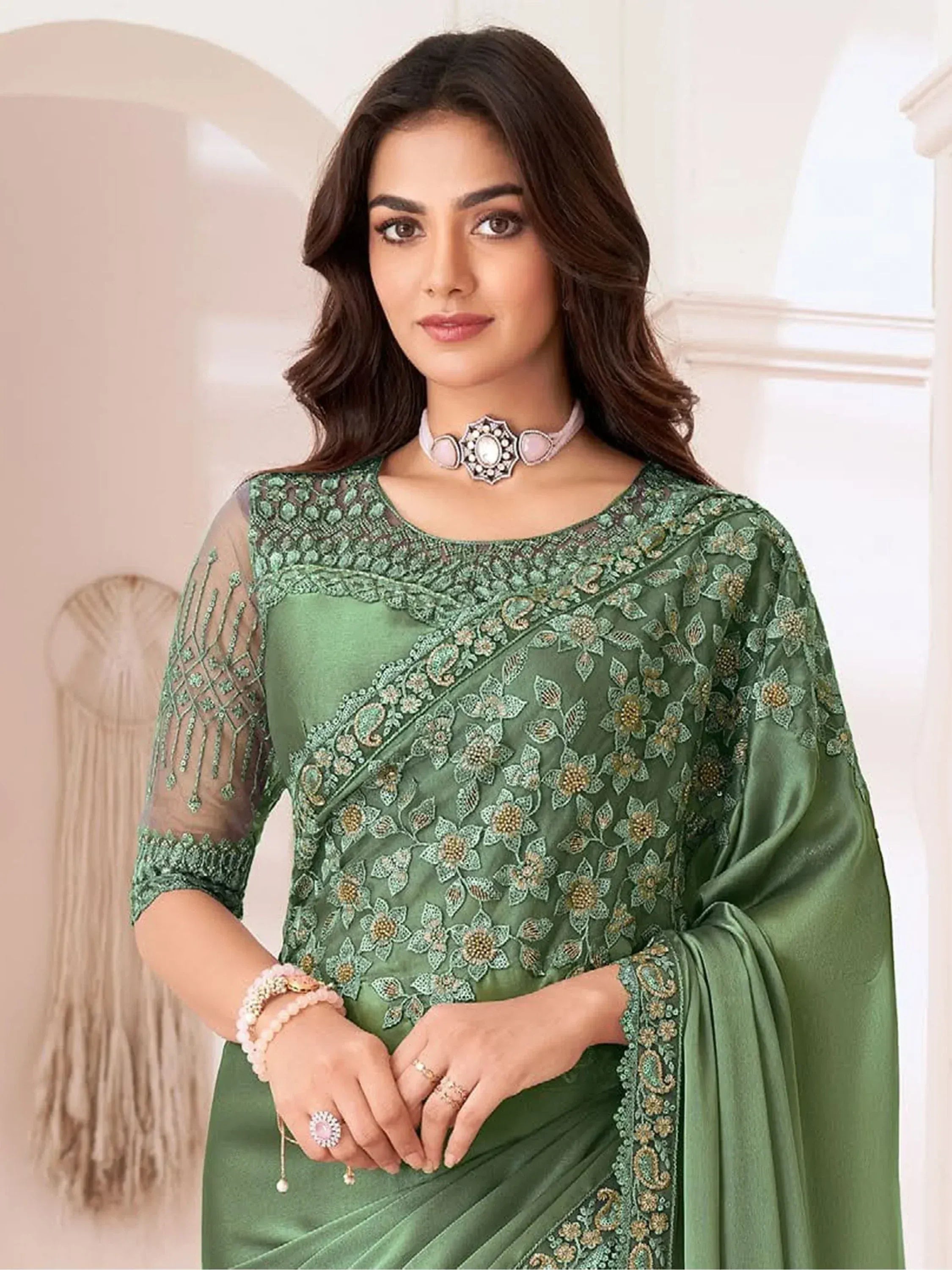 Elegant green embroidered saree with sheer sleeves and floral detailing, perfect for Indian ethnic occasions.