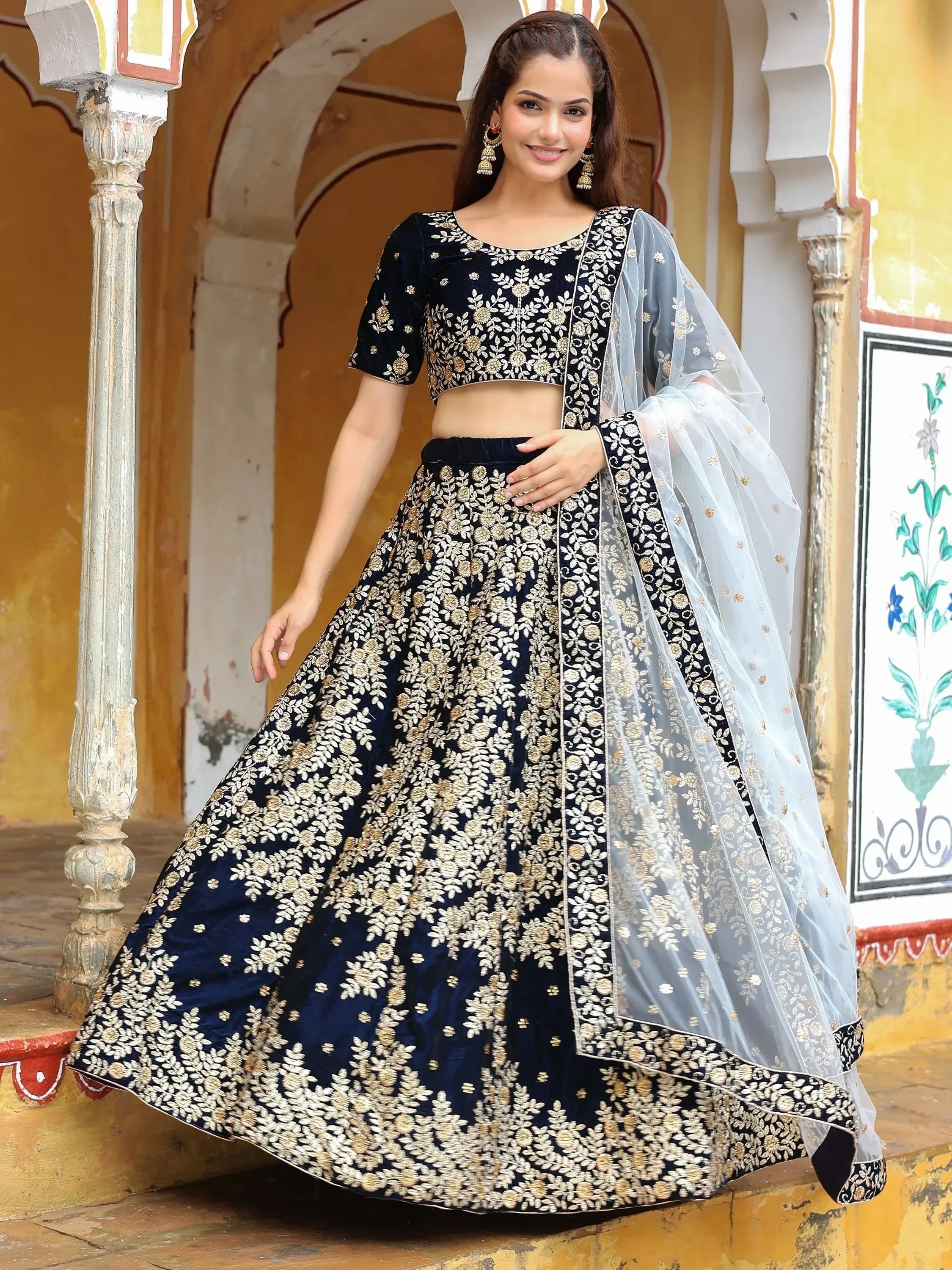 Navy blue velvet lehenga choli with gold floral embroidery and sheer dupatta, perfect for Indian ethnic occasions
