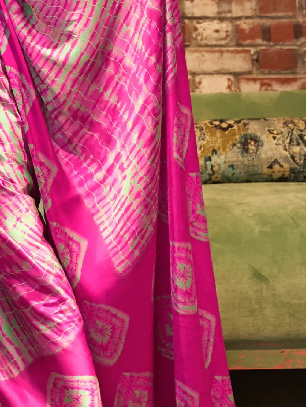 Vibrant pink ethnic saree with green ikat pattern, perfect for festive occasions