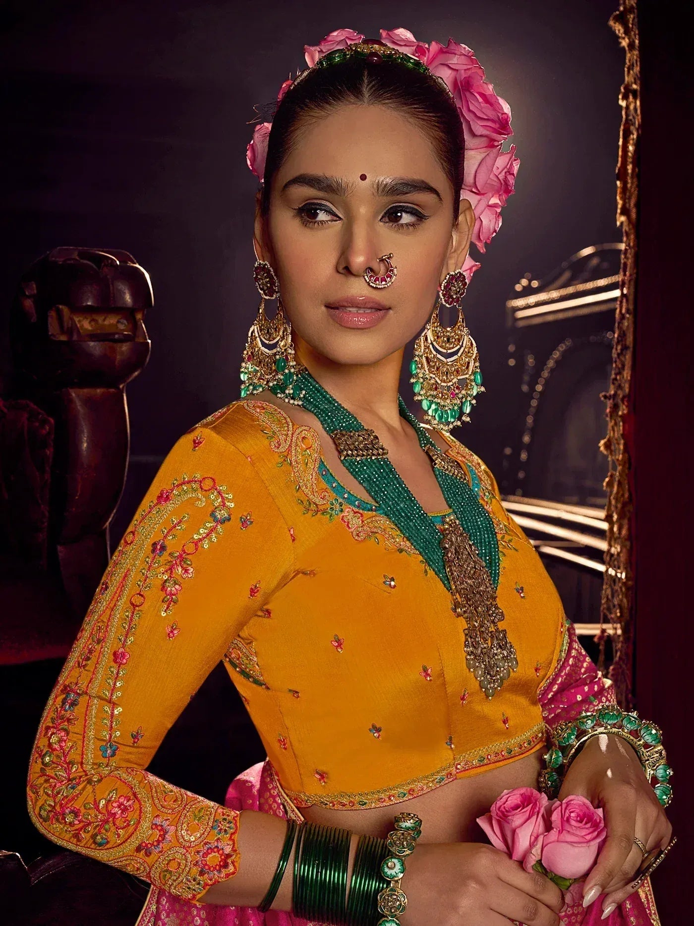 Yellow embroidered lehenga choli with green dupatta, floral headpiece, and traditional Indian jewelry