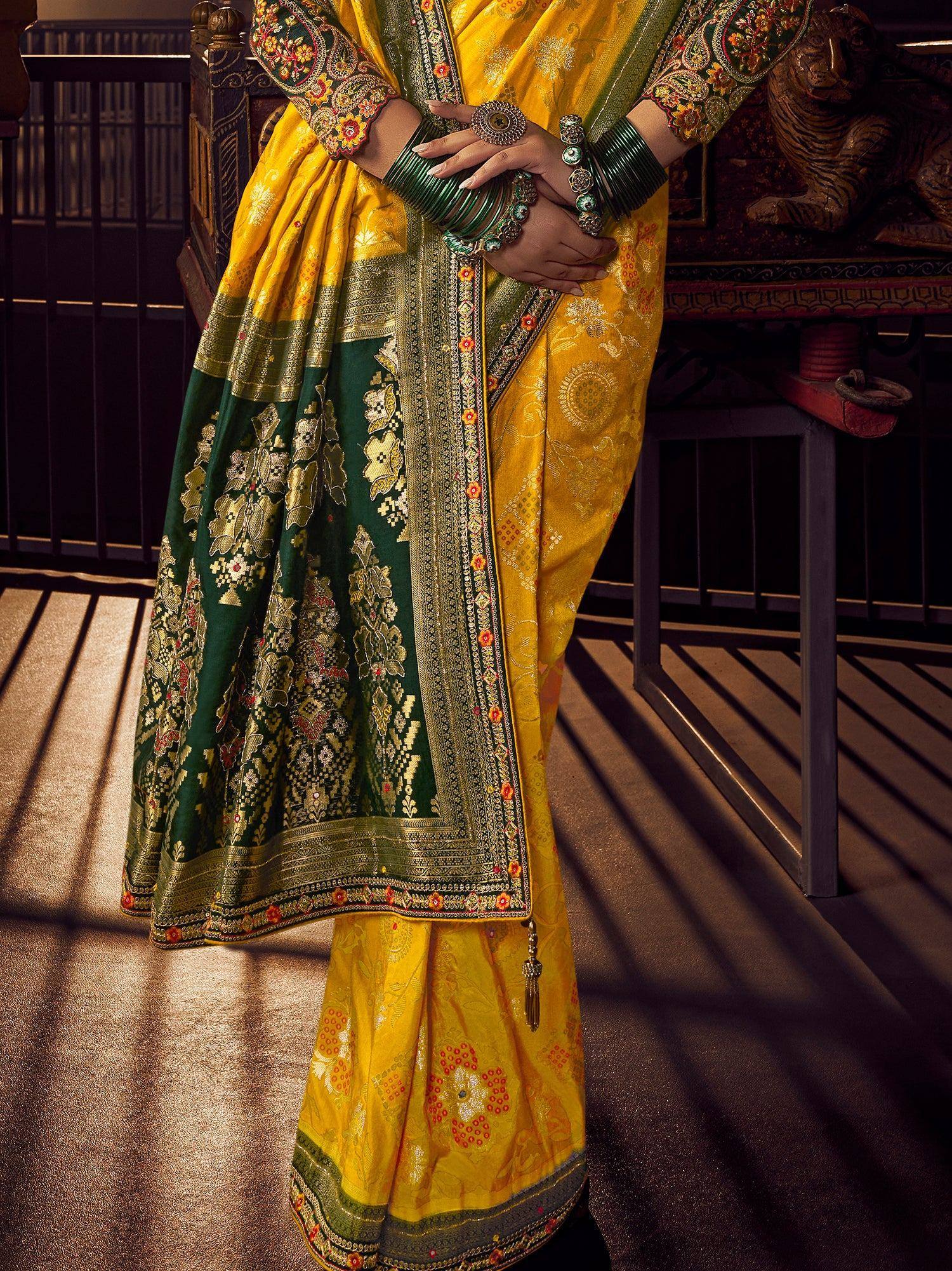 Yellow and green designer saree with intricate embroidery and traditional jewelry