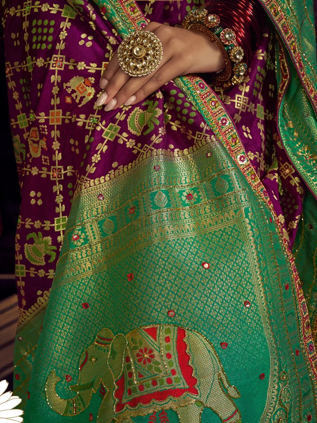 Purple and green ethnic saree with elephant motifs, gold embroidery, and traditional jewelry