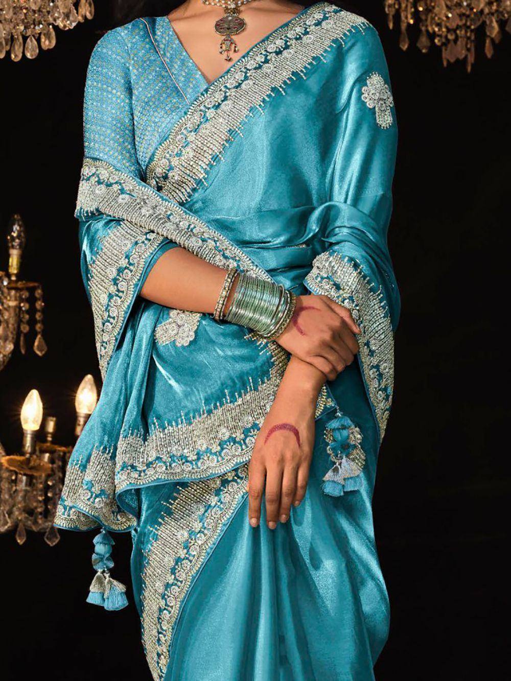 Turquoise designer saree with silver embroidery and tassels, perfect for Indian ethnic wear occasions