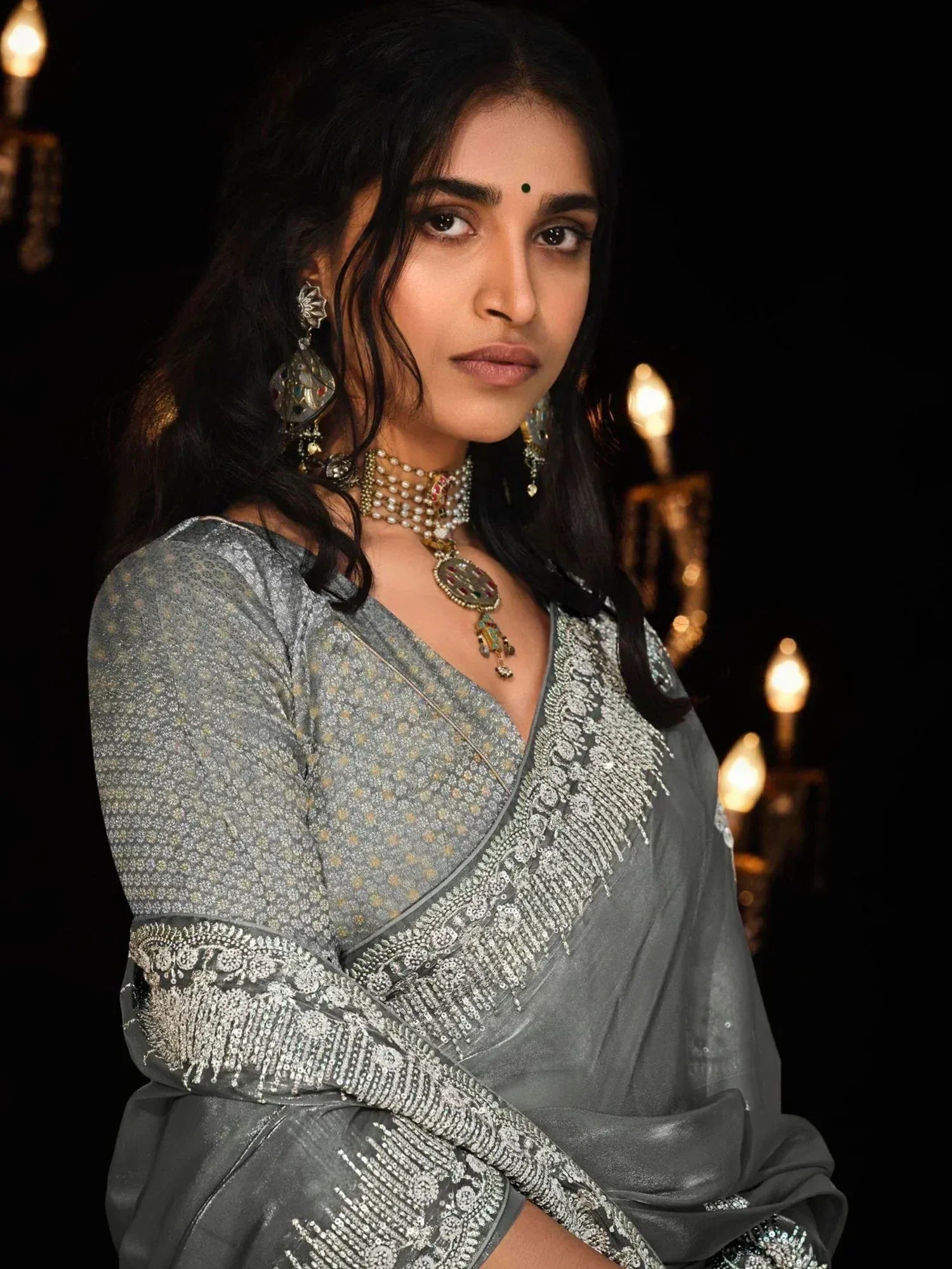 Grey embroidered saree with sequin detailing, paired with traditional Indian jewelry for ethnic wear.