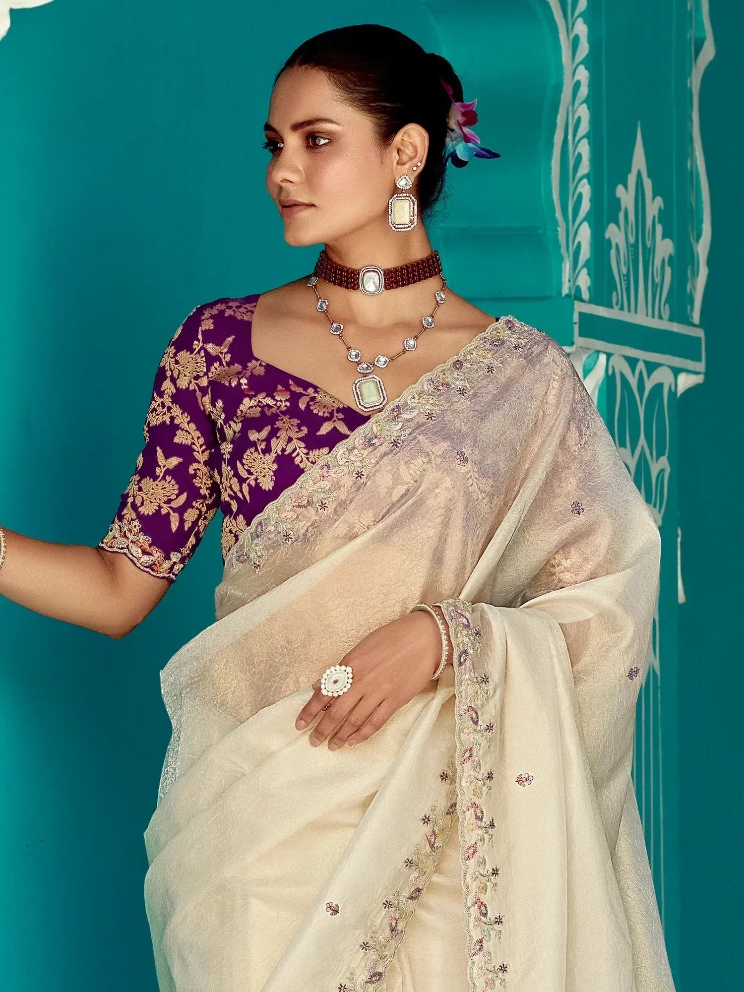 Elegant cream saree with floral embroidery paired with purple blouse, perfect for Indian ethnic occasions.