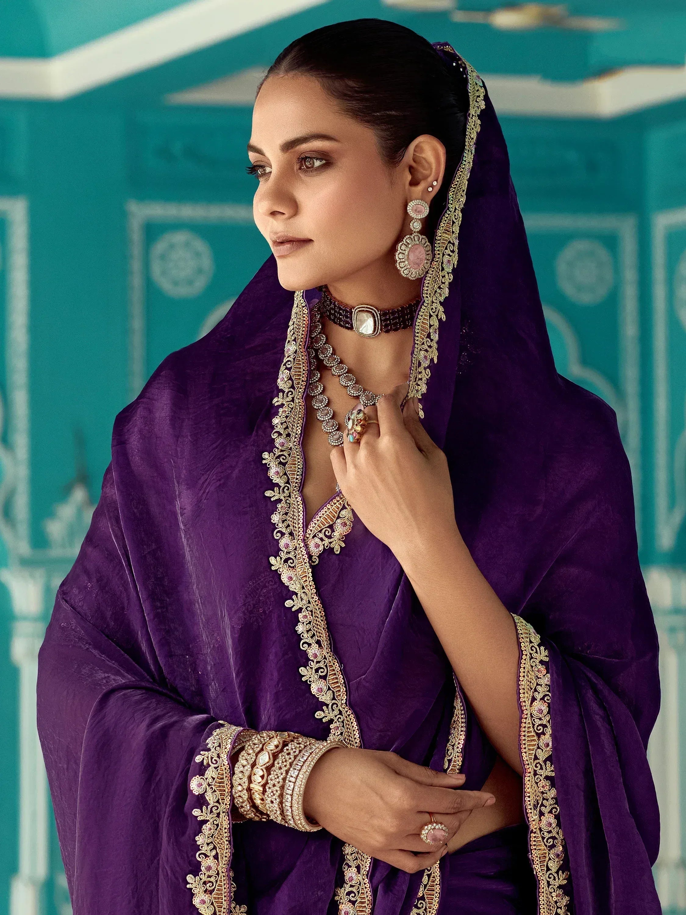 Elegant purple velvet ethnic gown with gold embroidery, perfect for Indian weddings and festive occasions.