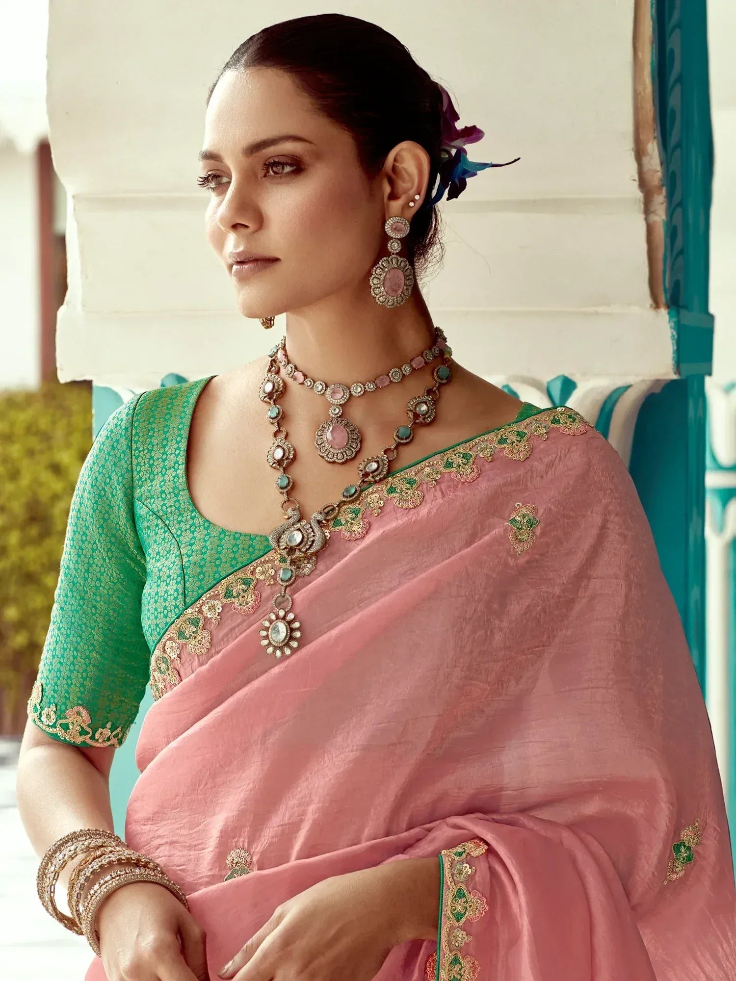Elegant pink saree with green blouse, gold embroidery, and traditional jewelry for Indian ethnic wear