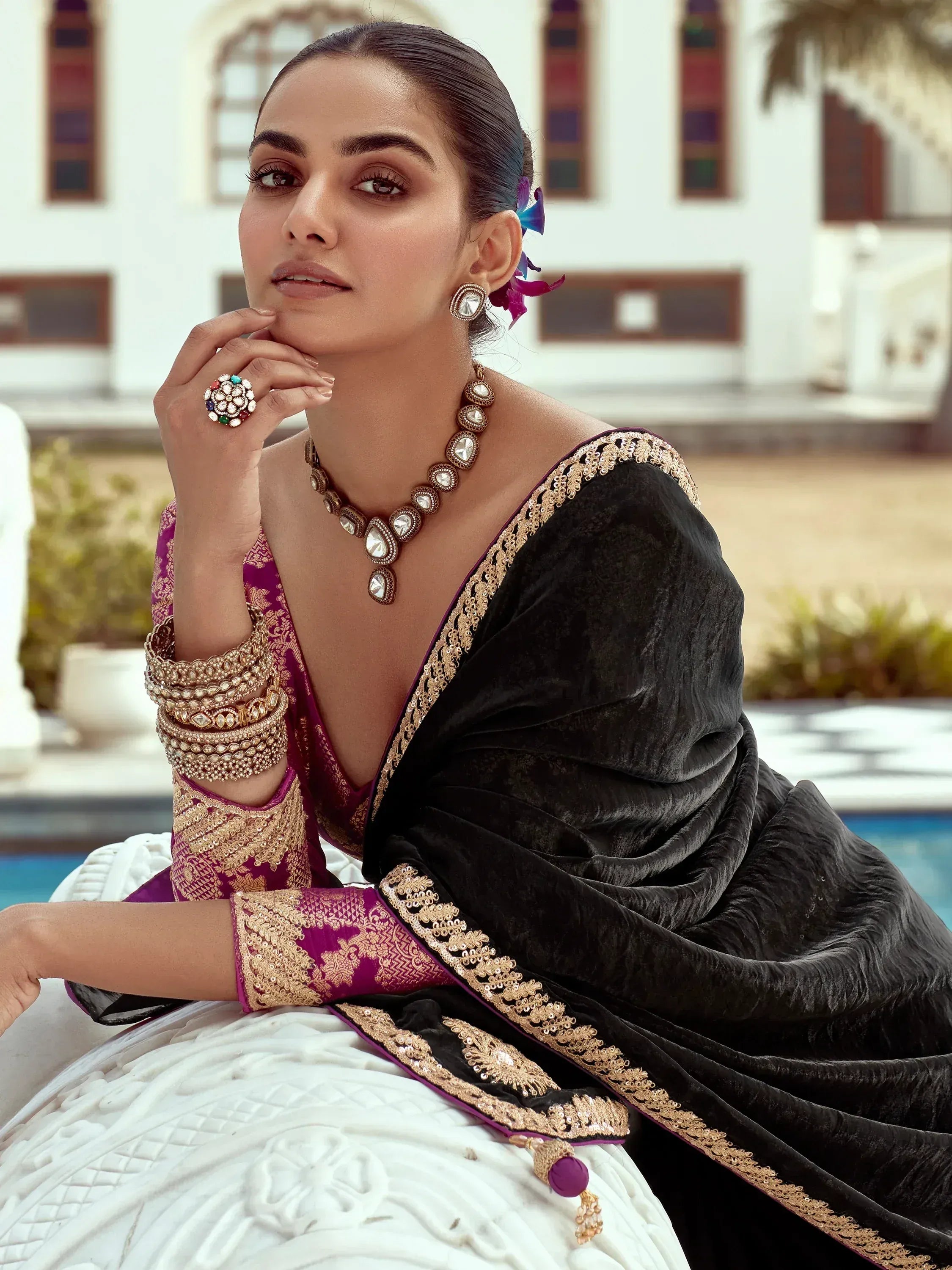 Elegant woman in purple and black velvet lehenga choli with gold embroidery, perfect for Indian ethnic wear.