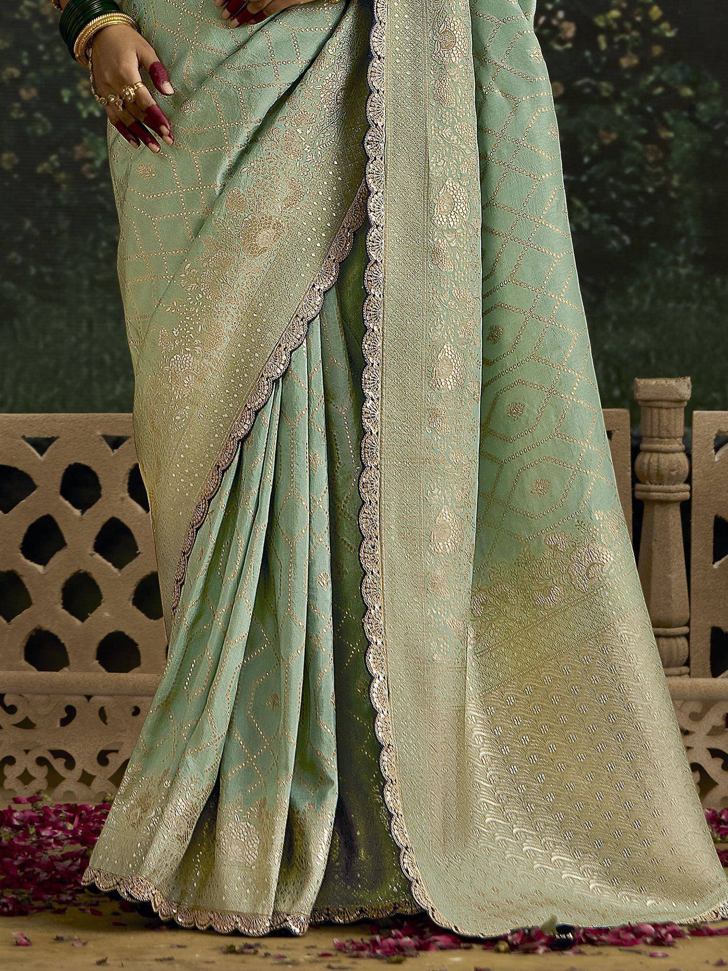 Mint green designer saree with gold geometric embroidery and scalloped border, perfect for ethnic occasions.