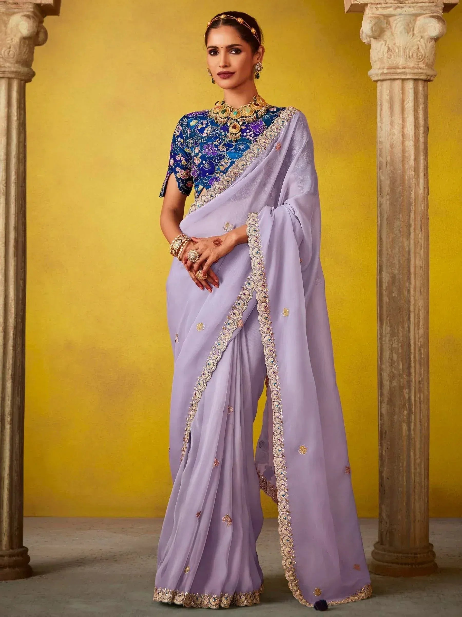 Lavender saree with floral blouse and gold embroidery, styled with traditional Indian jewelry