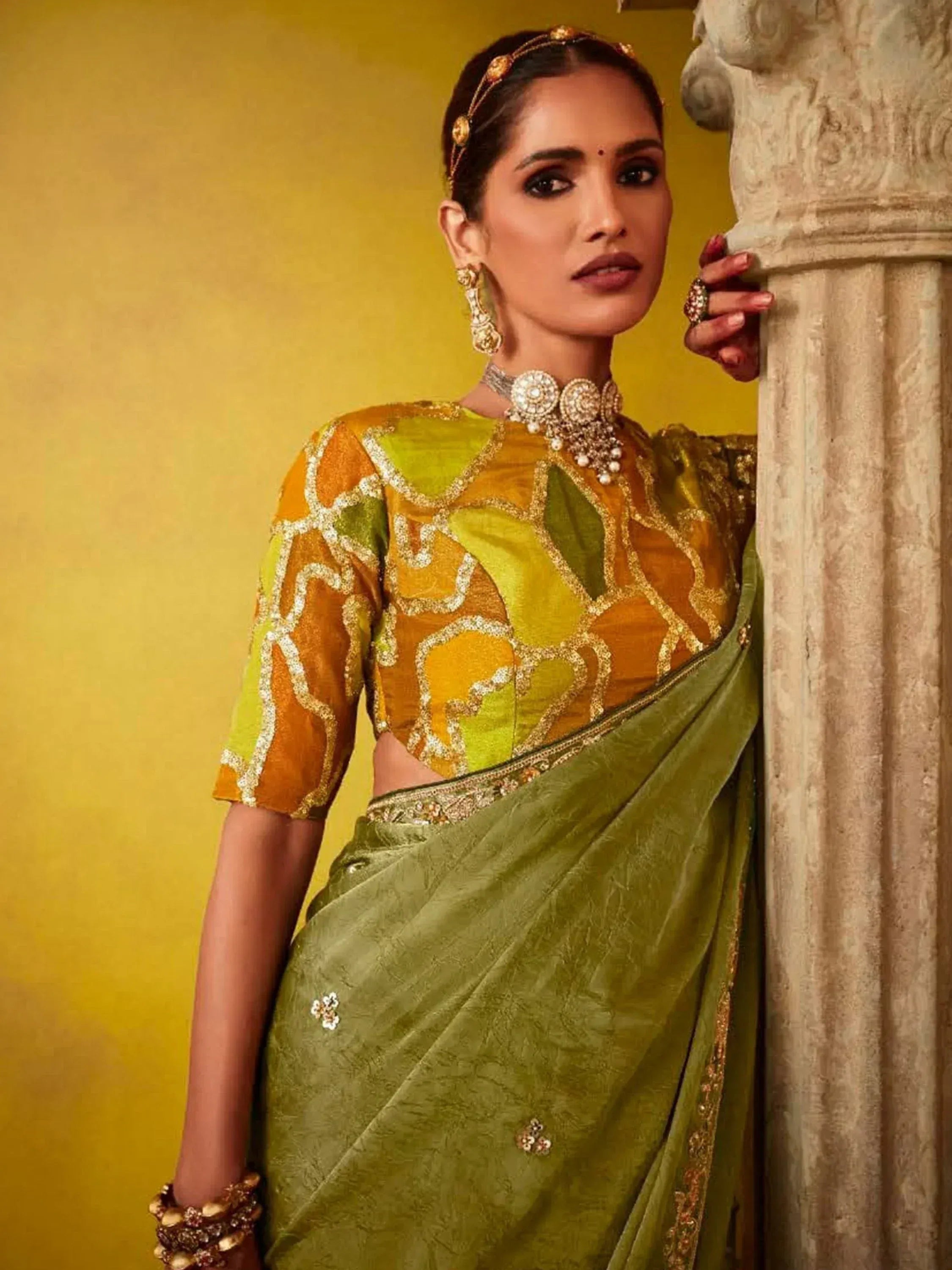 Woman in green and gold embroidered saree with designer blouse, traditional Indian ethnic wear