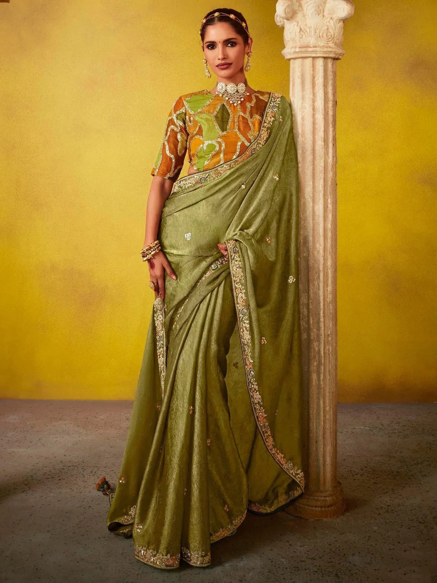 Olive green designer saree with gold embroidery, paired with patterned blouse, perfect for Indian ethnic occasions.
