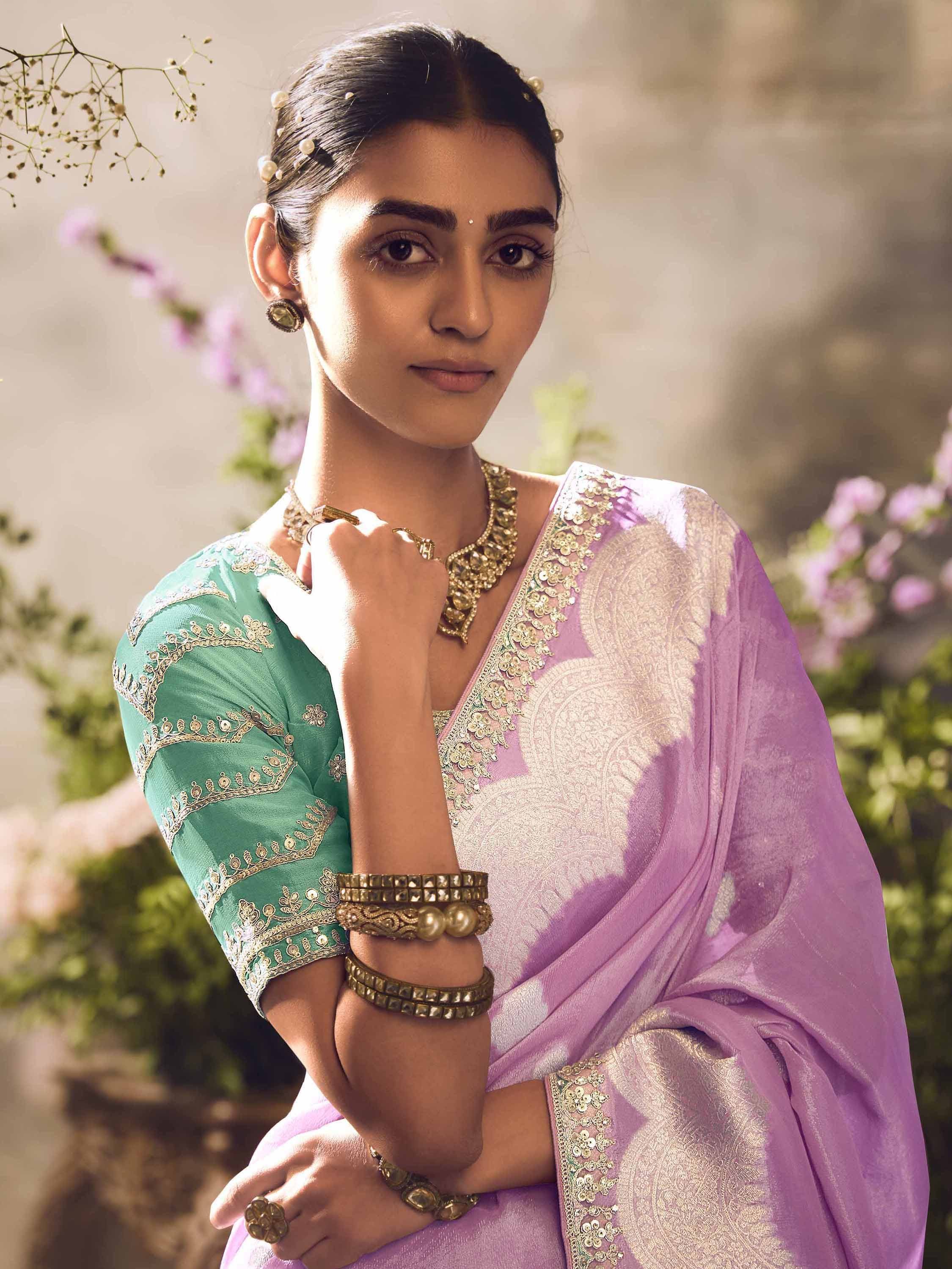 Woman in purple saree with gold embroidery and green blouse, styled with traditional Indian jewelry