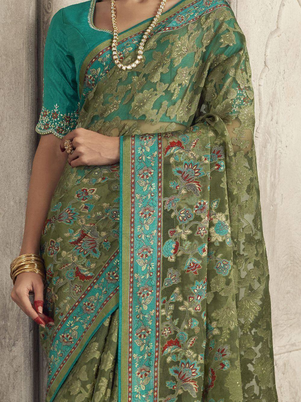 Green floral embroidered saree with teal border, paired with matching blouse and gold jewelry