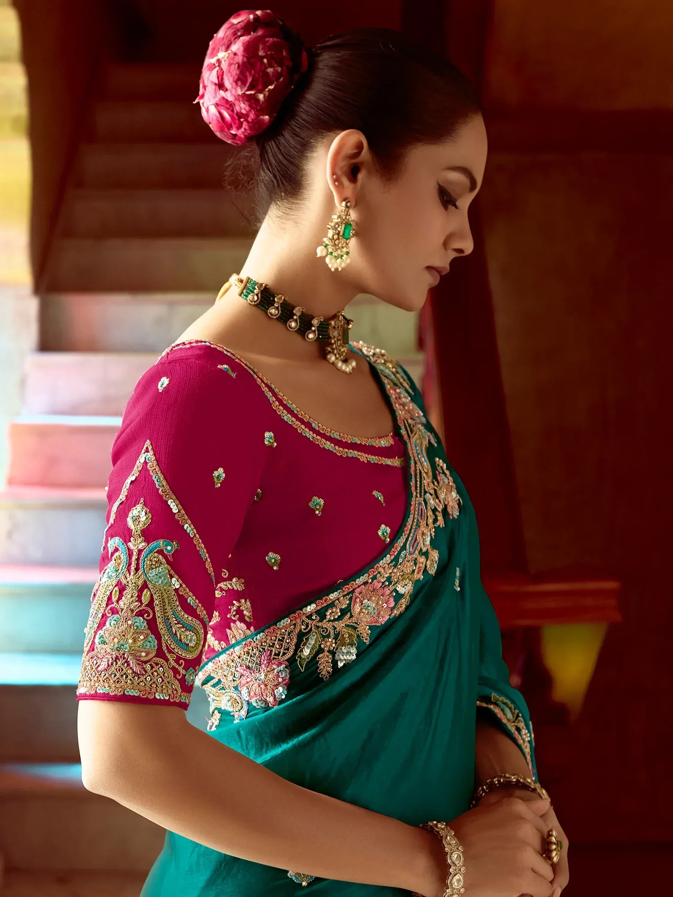 Elegant teal saree with maroon blouse, intricate gold embroidery, and traditional jewelry for Indian ethnic wear.