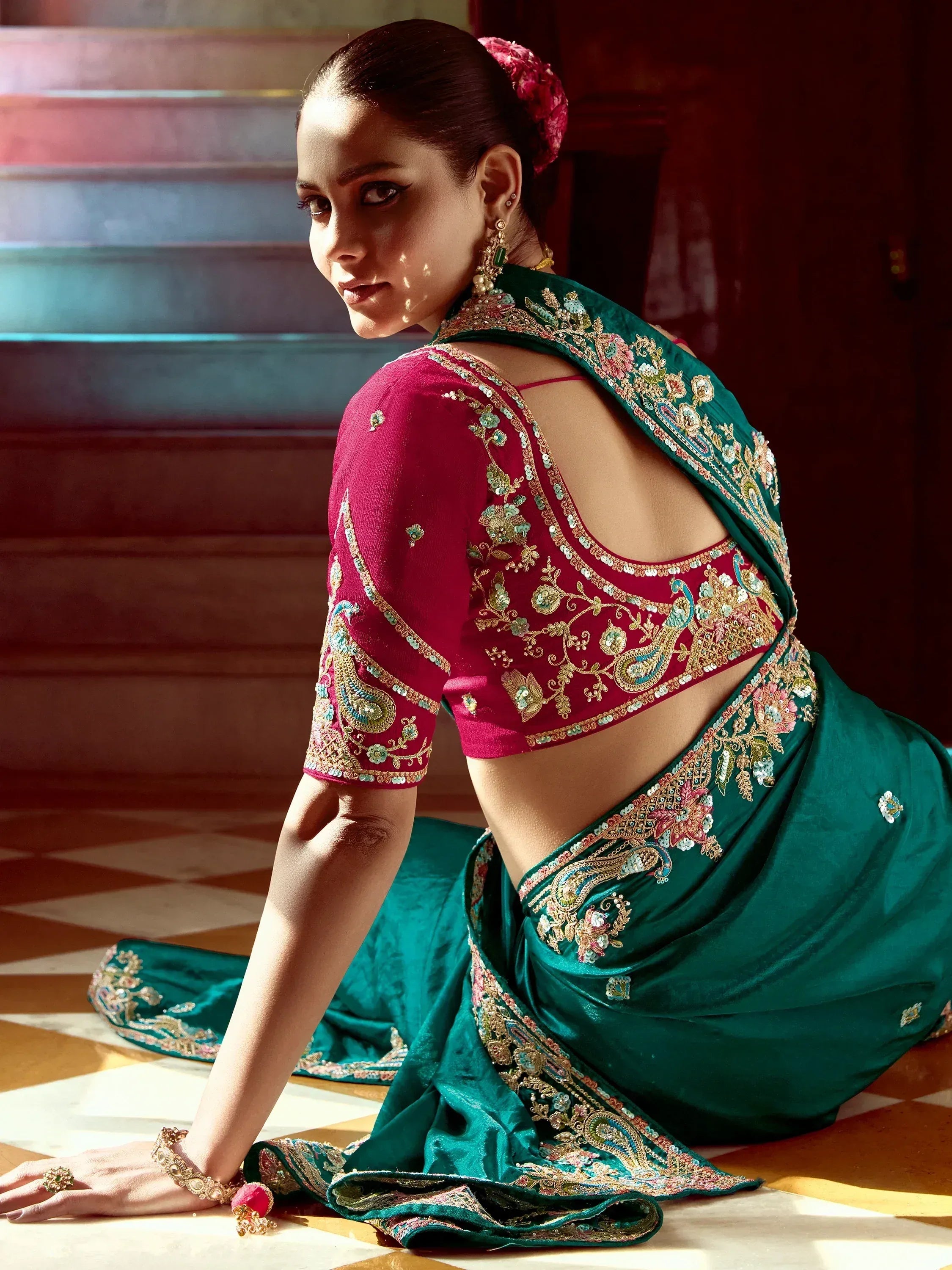 Elegant green saree with maroon blouse, intricate floral embroidery, and peacock motifs for Indian ethnic wear.