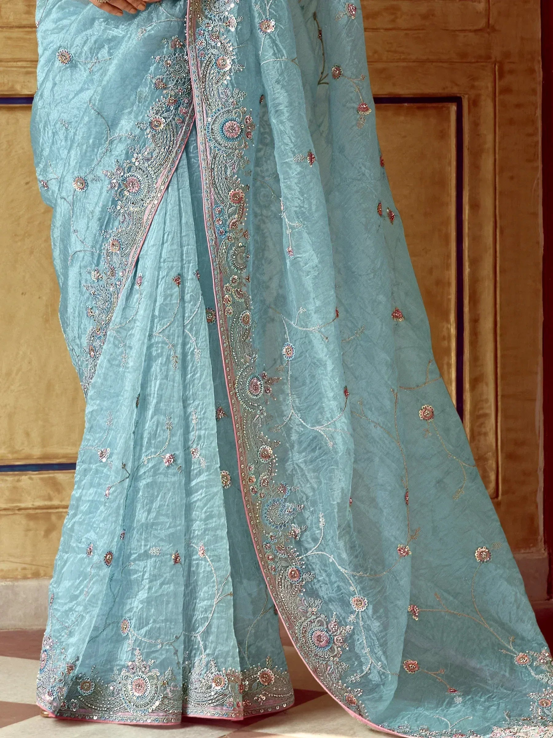 Light blue embroidered saree with floral motifs and pink border, perfect for ethnic occasions