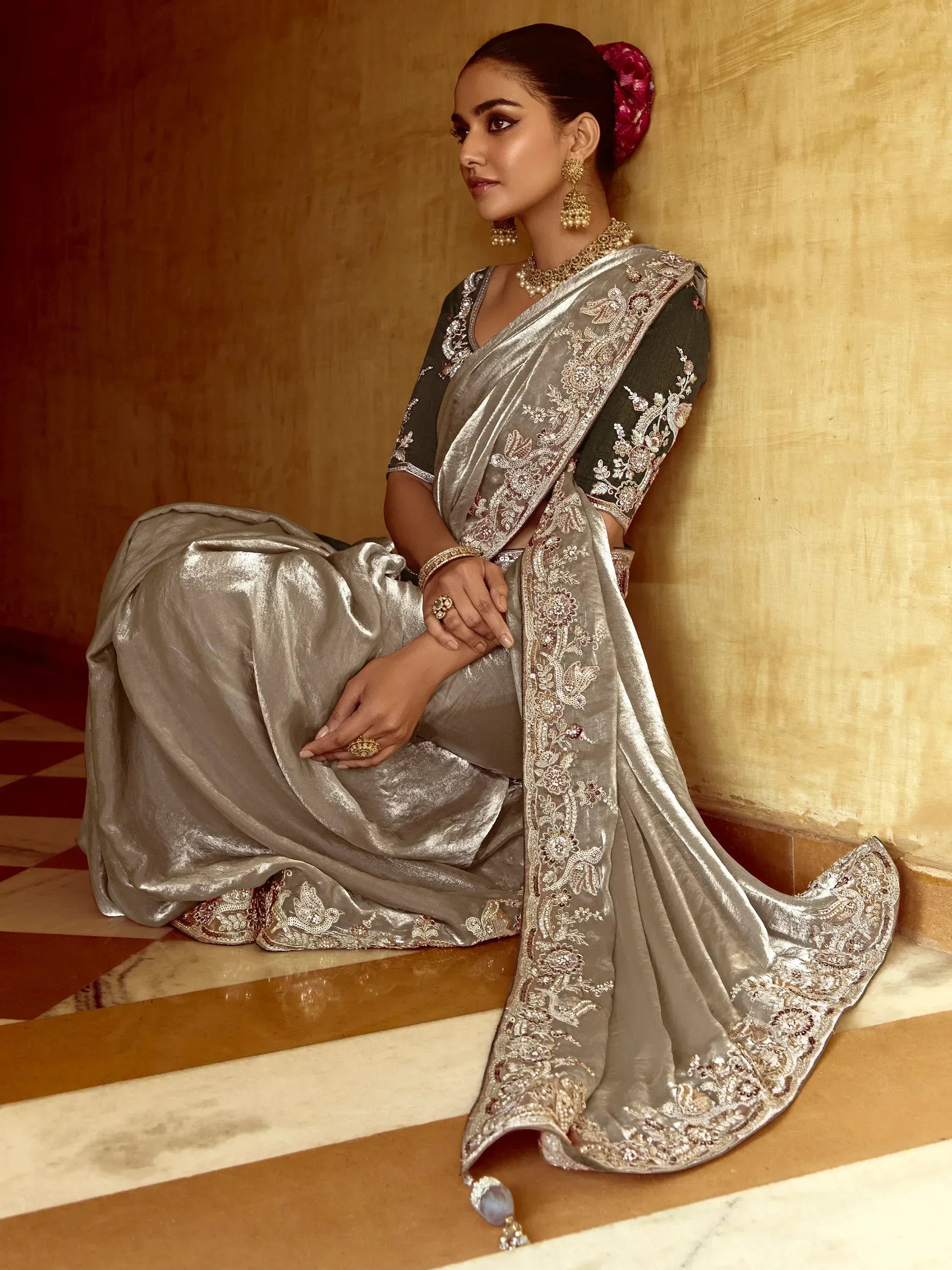 Elegant silver saree with intricate embroidery and gold jewelry, perfect for Indian ethnic occasions.