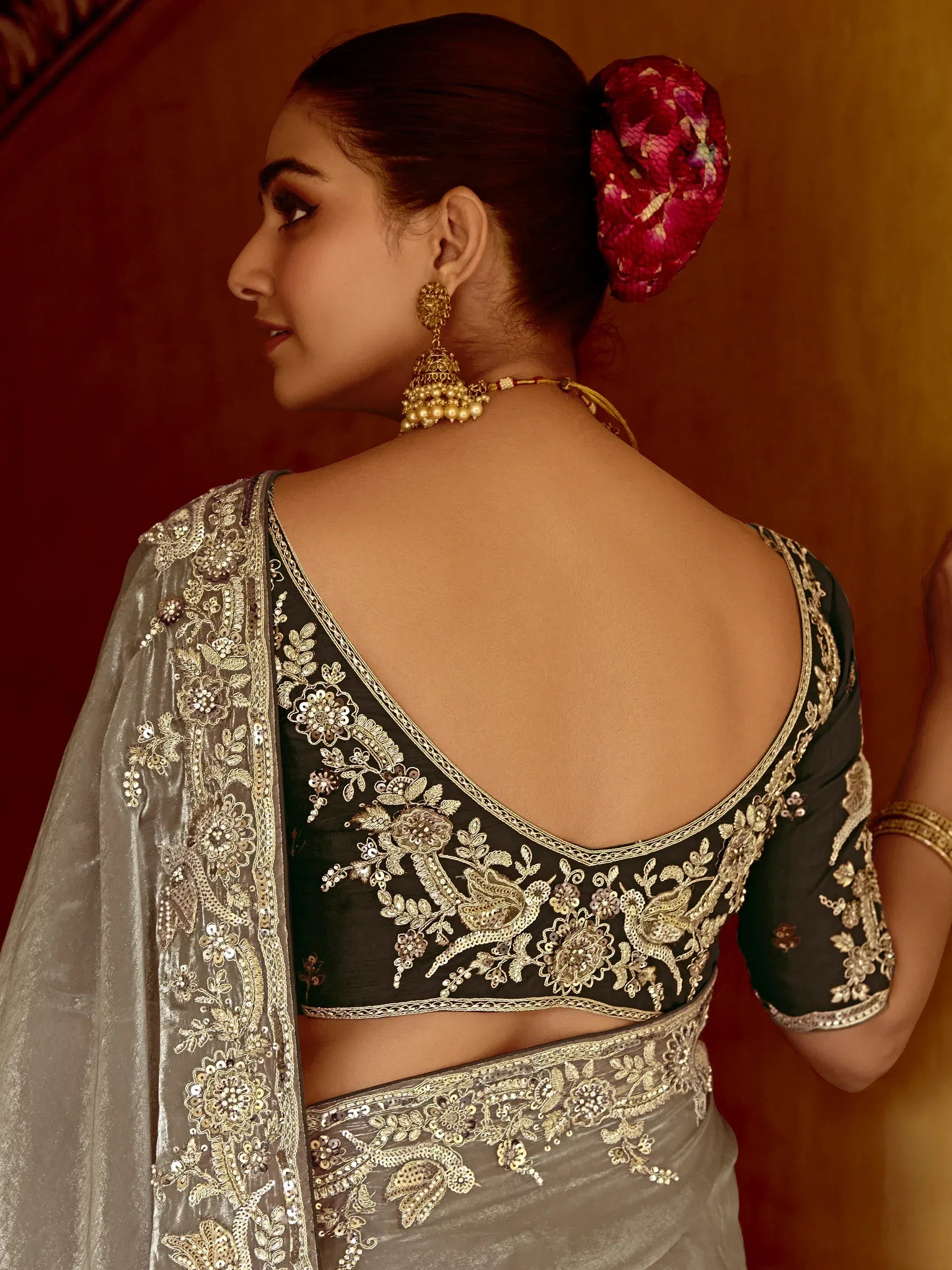 Elegant black and silver saree with intricate gold embroidery and backless blouse design