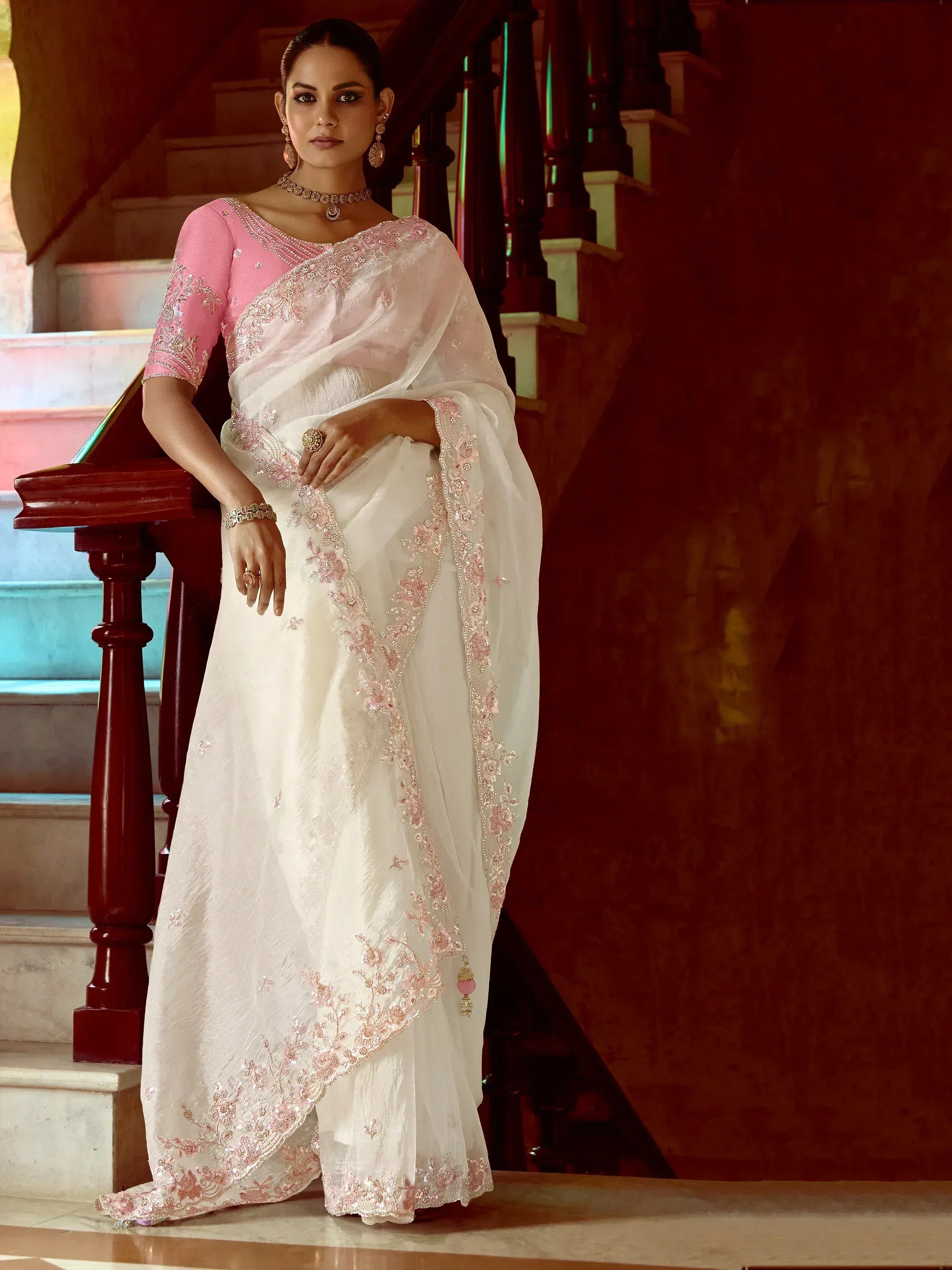Elegant white saree with pink embroidery, paired with a matching blouse, perfect for Indian ethnic occasions.