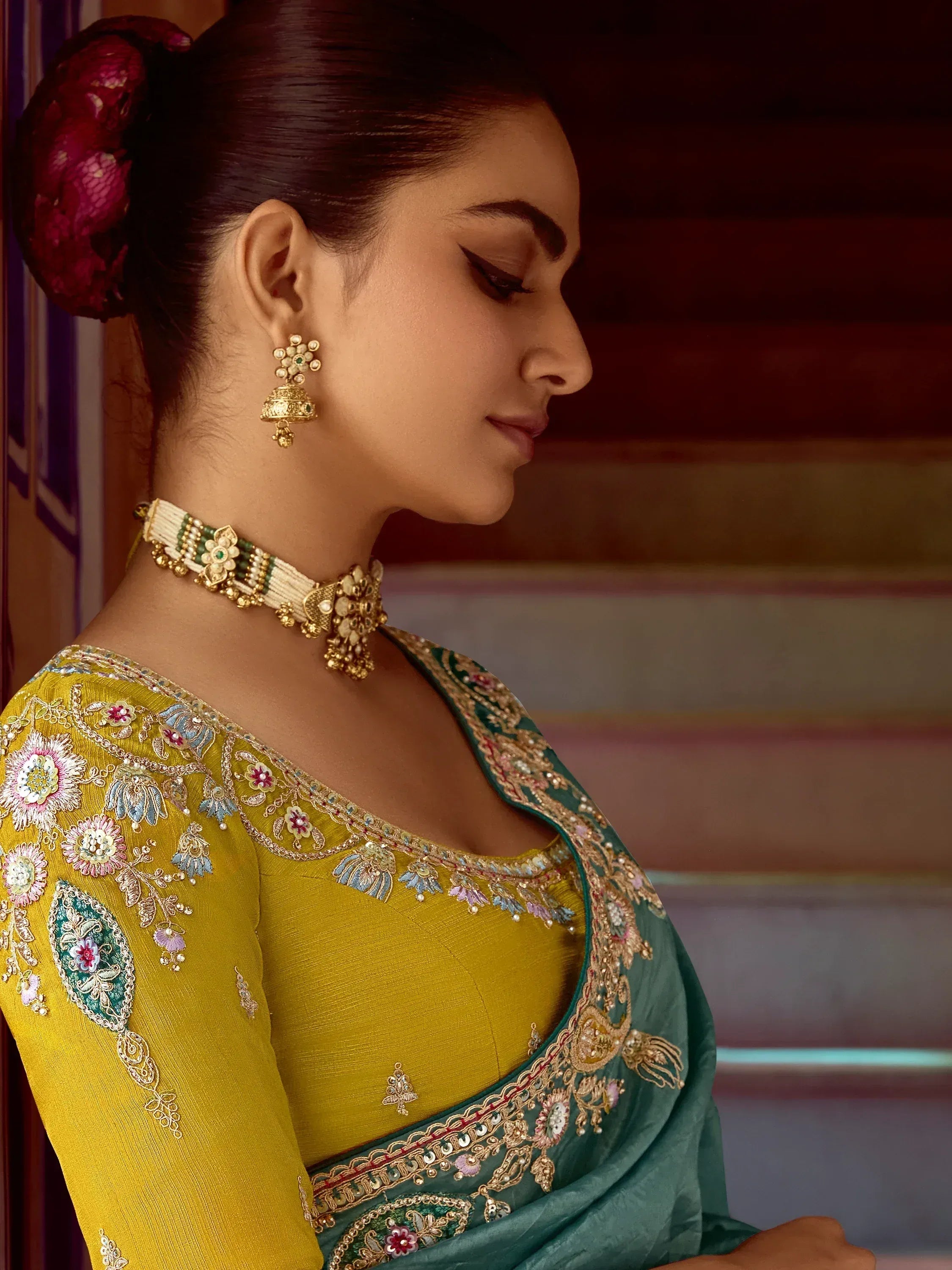 Elegant woman in yellow and green embroidered ethnic wear with gold jewelry