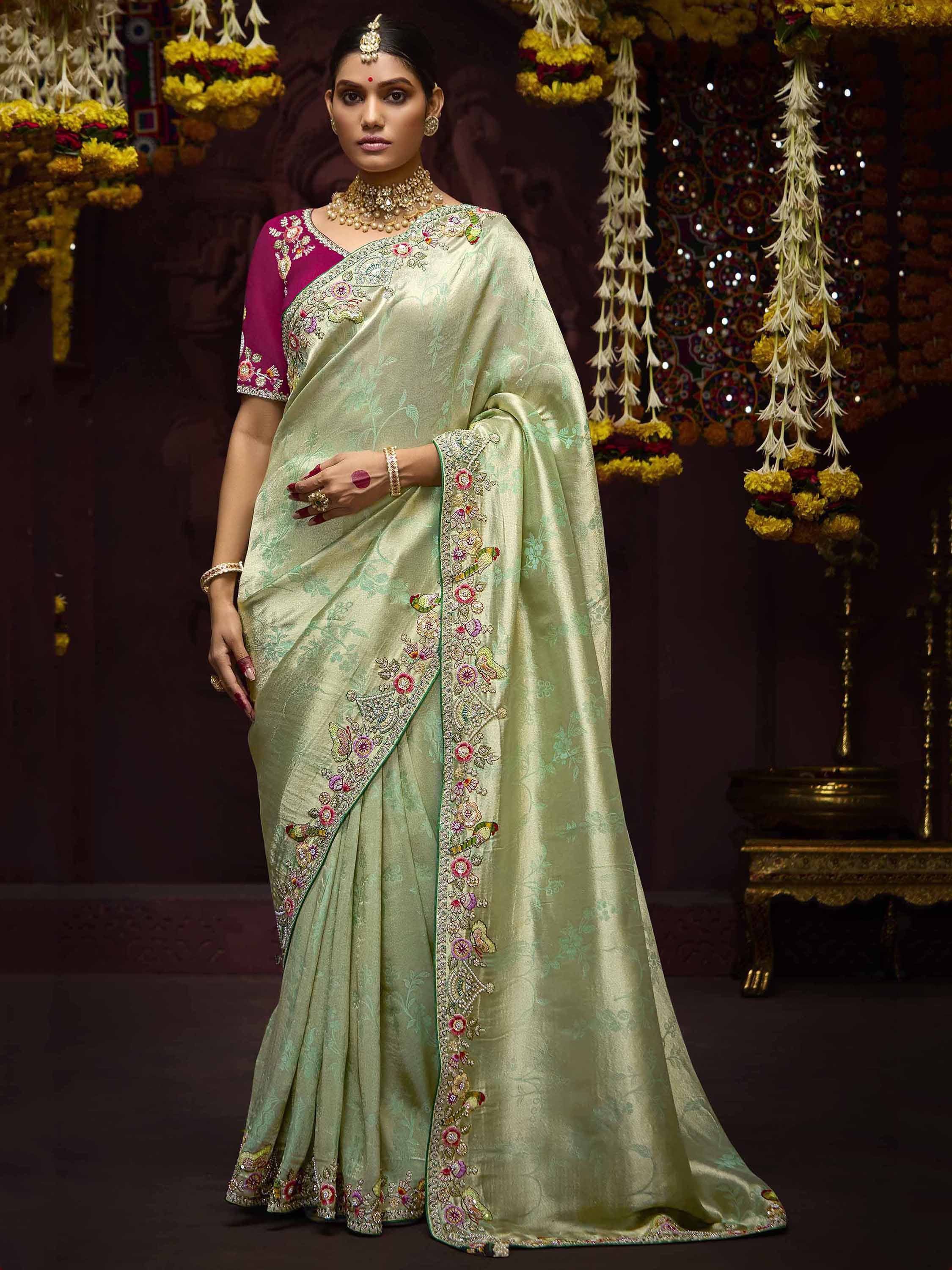 Elegant light green embroidered saree with floral motifs and magenta blouse, perfect for Indian ethnic occasions.