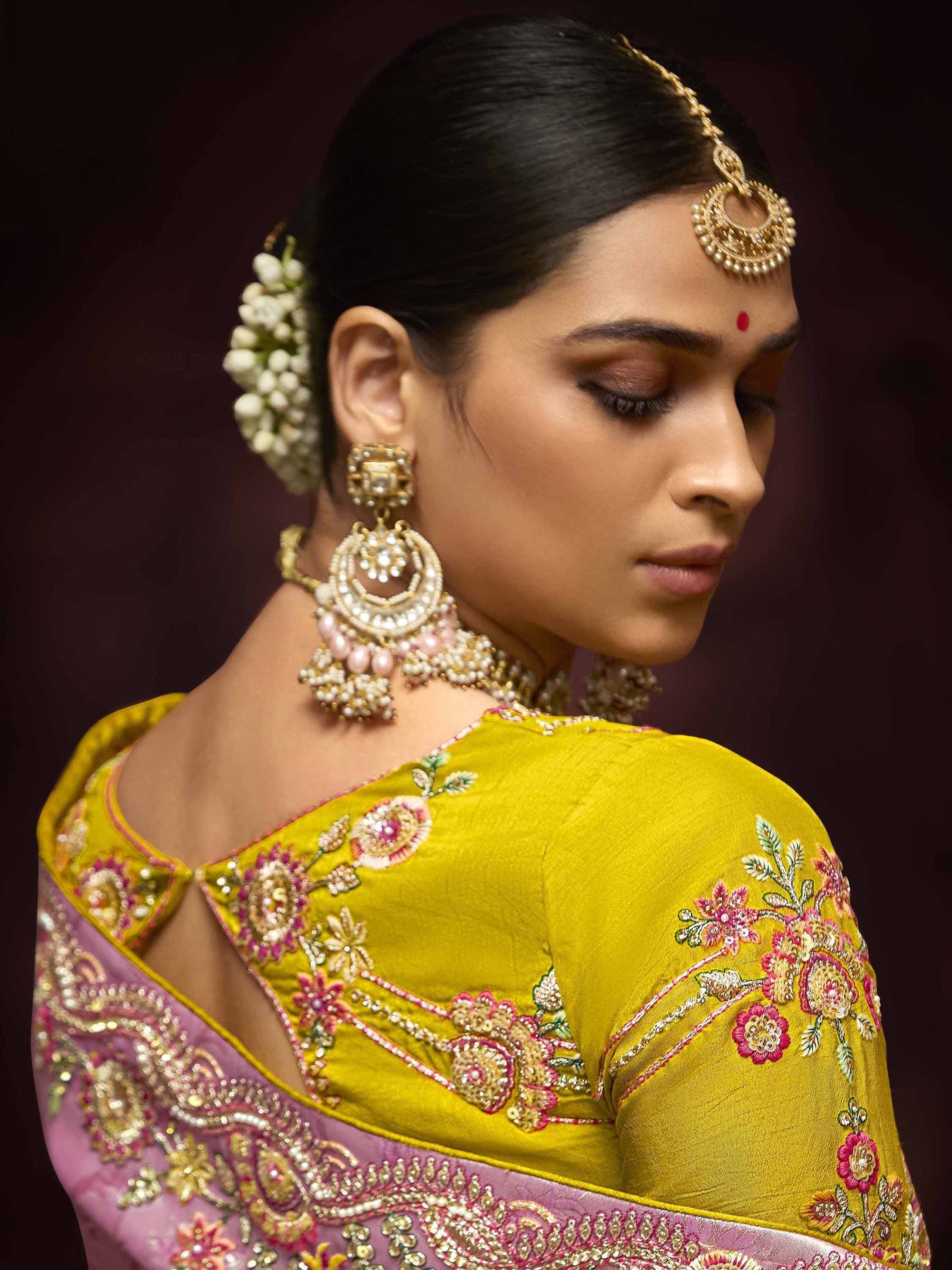 Elegant Indian bride in yellow floral embroidered saree with gold jewelry and maang tikka