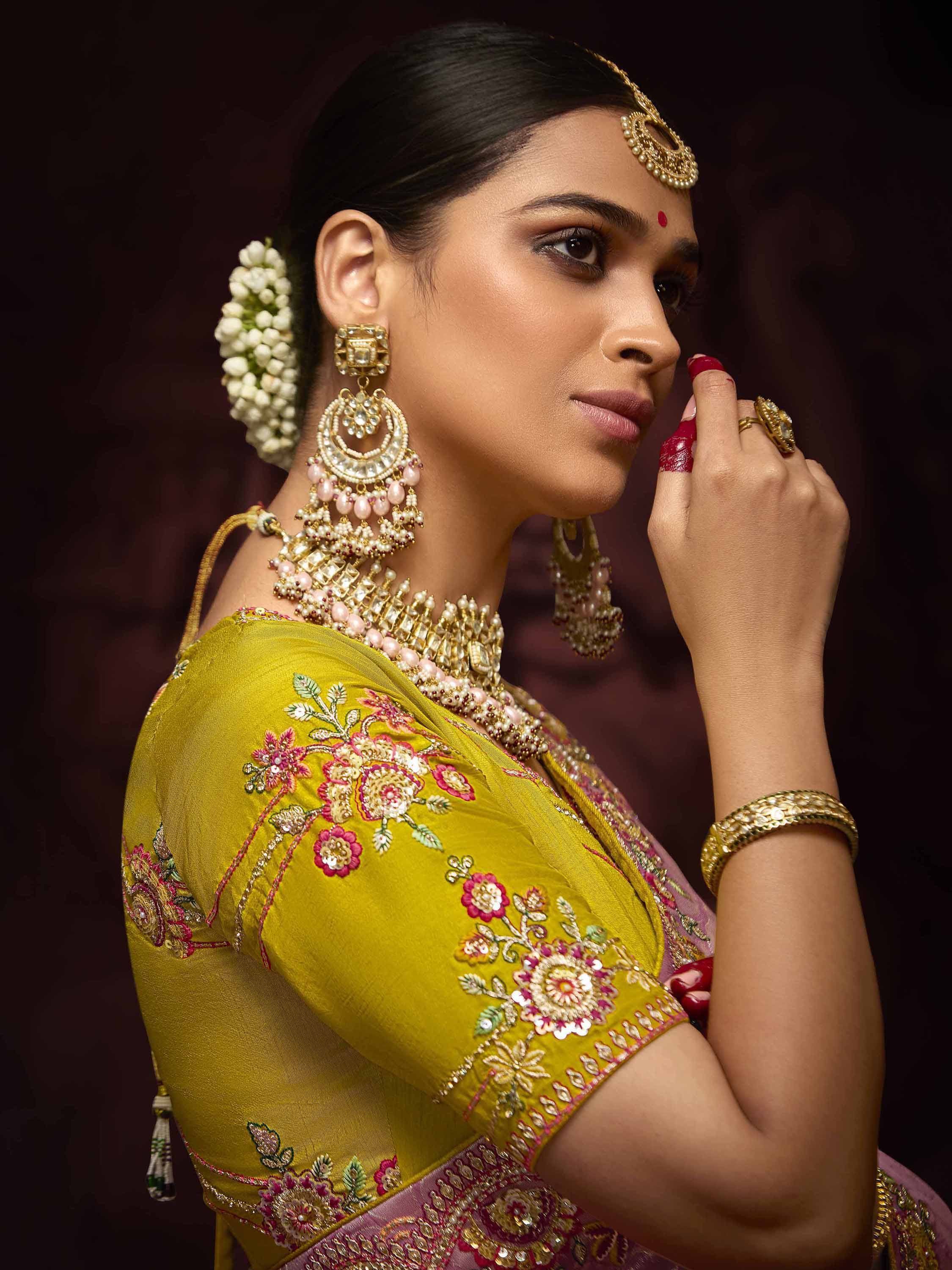 Woman in yellow embroidered saree with gold jewelry and floral hair accessory, Indian ethnic wear