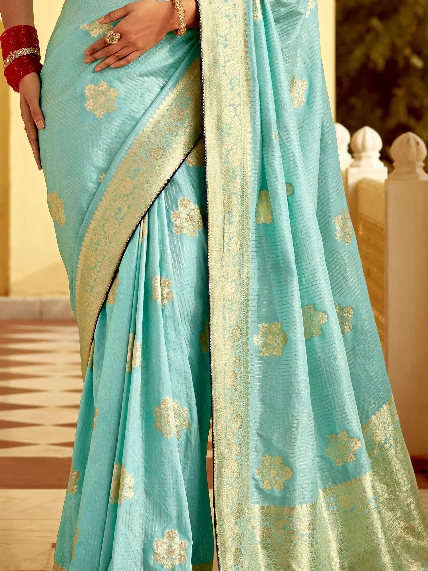 Light blue saree with gold floral motifs and intricate border design
