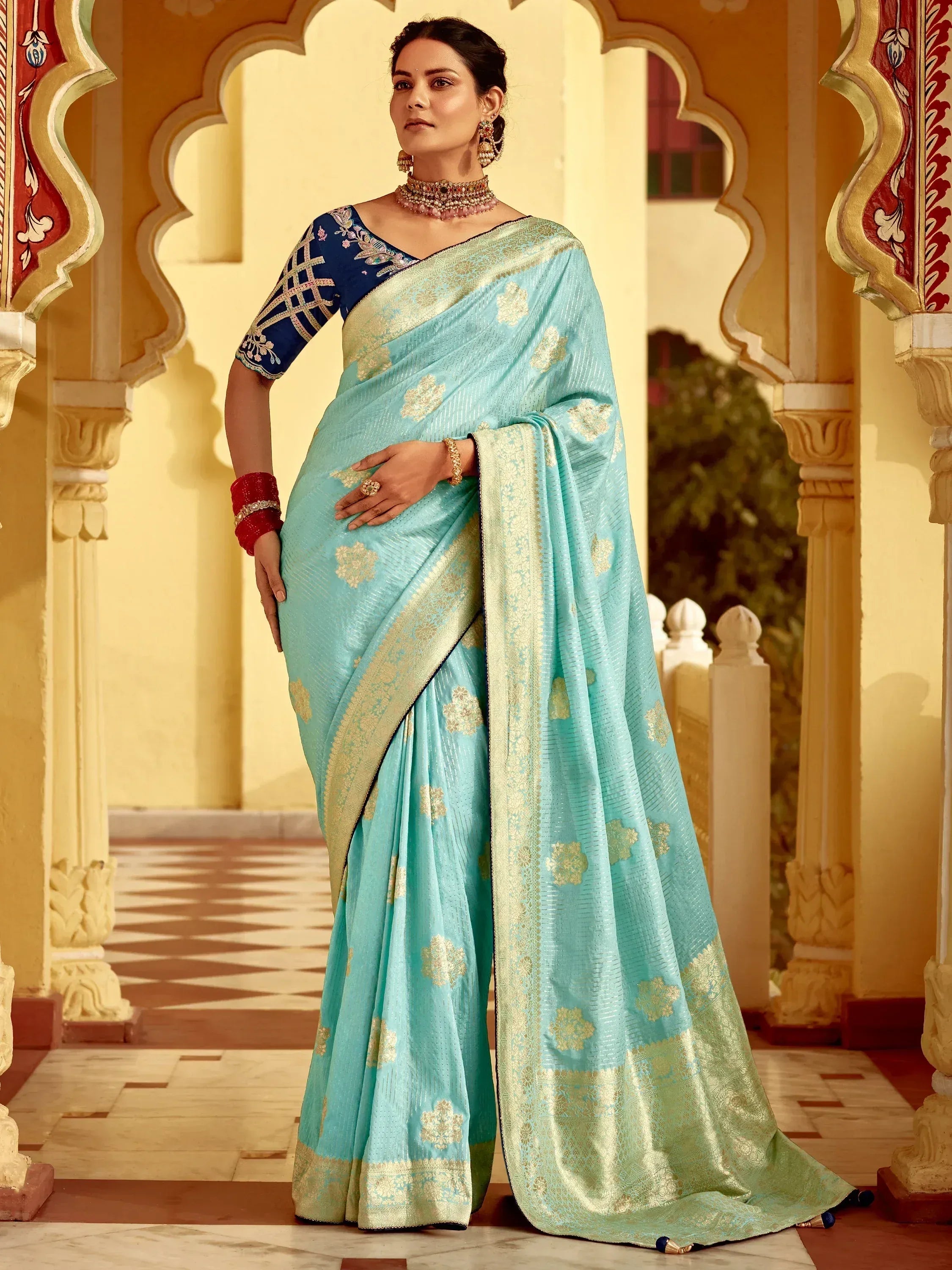 Elegant light blue saree with gold floral motifs and contrasting navy blouse, perfect for Indian ethnic occasions