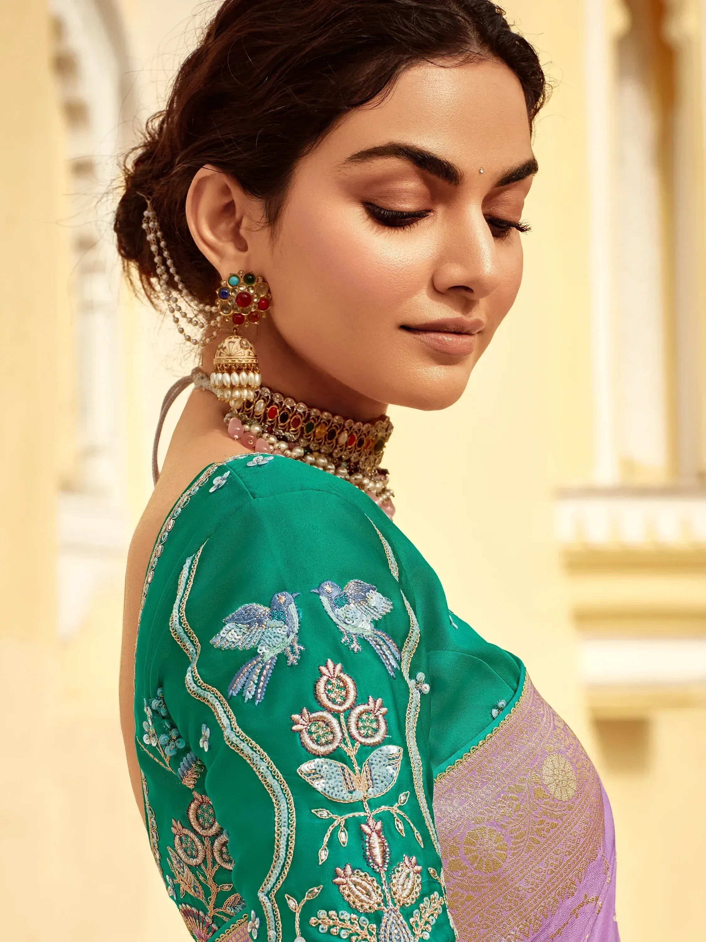Green embroidered saree with bird motifs, paired with traditional jewelry for ethnic wear