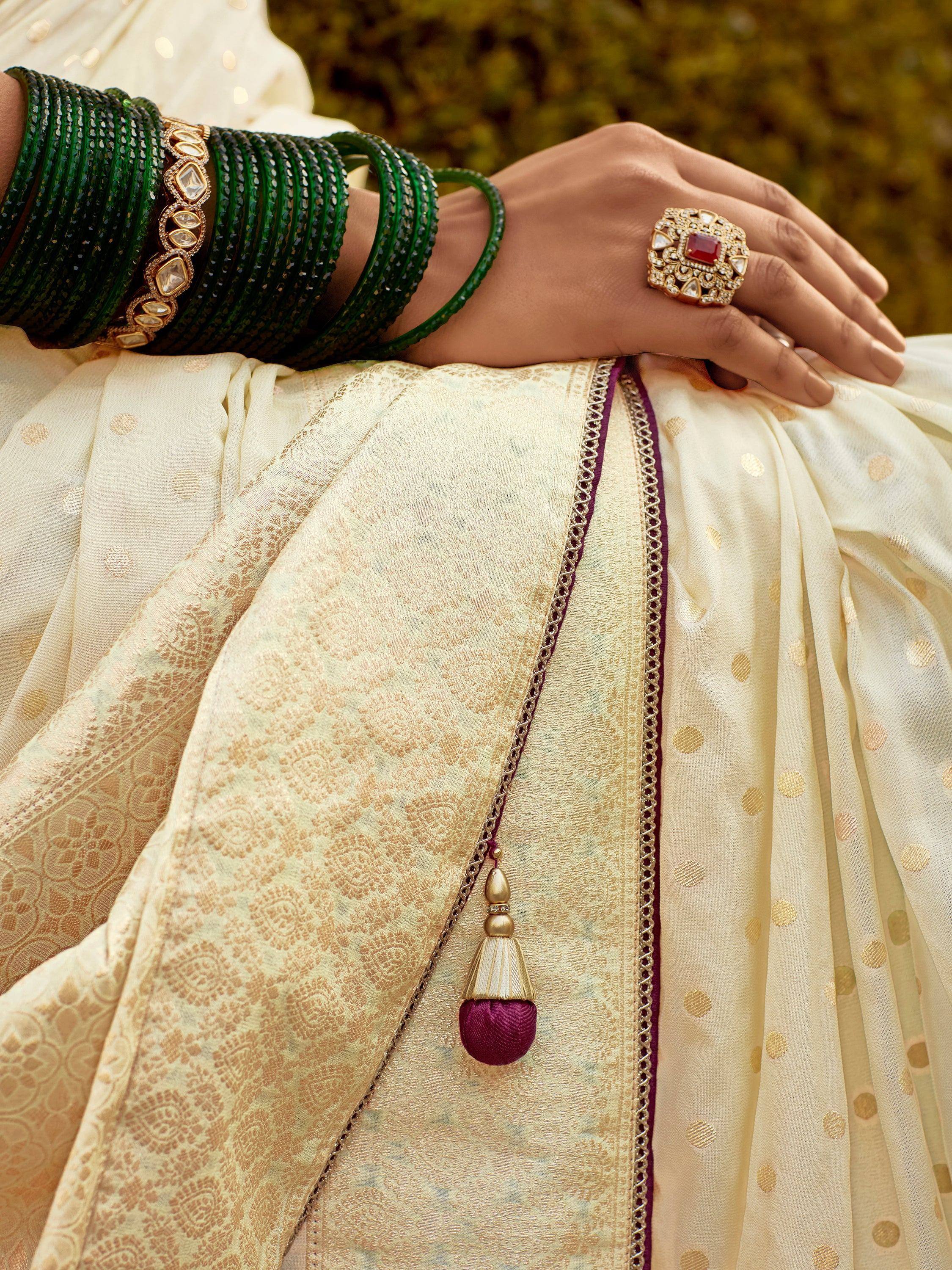 Elegant Indian ethnic wear with green bangles, ornate ring, and gold-patterned fabric