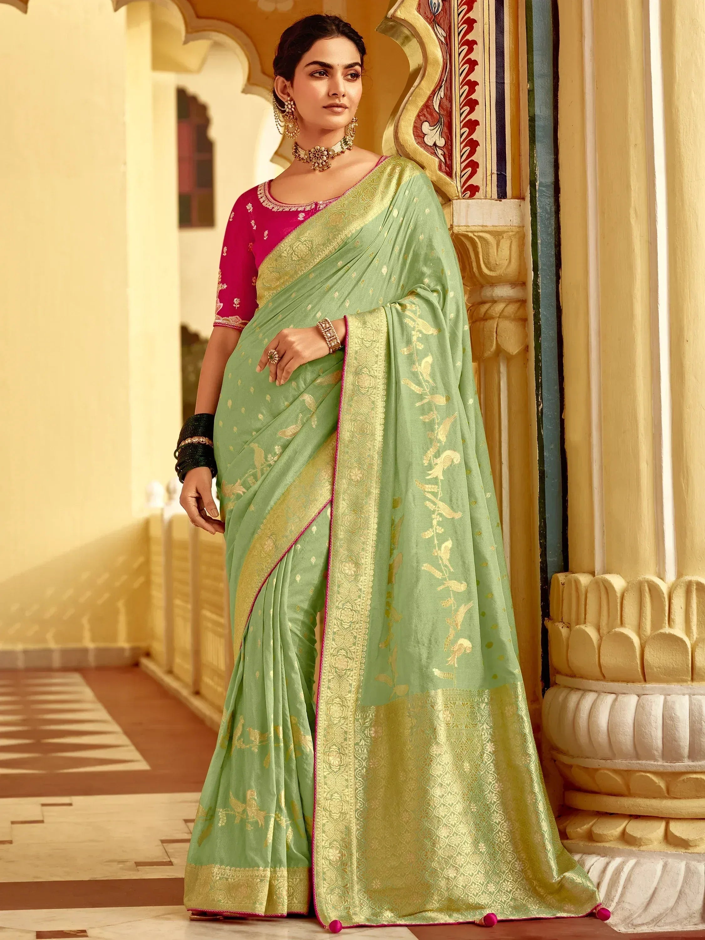 Elegant green saree with gold embroidery and pink blouse, perfect for Indian ethnic wear occasions.