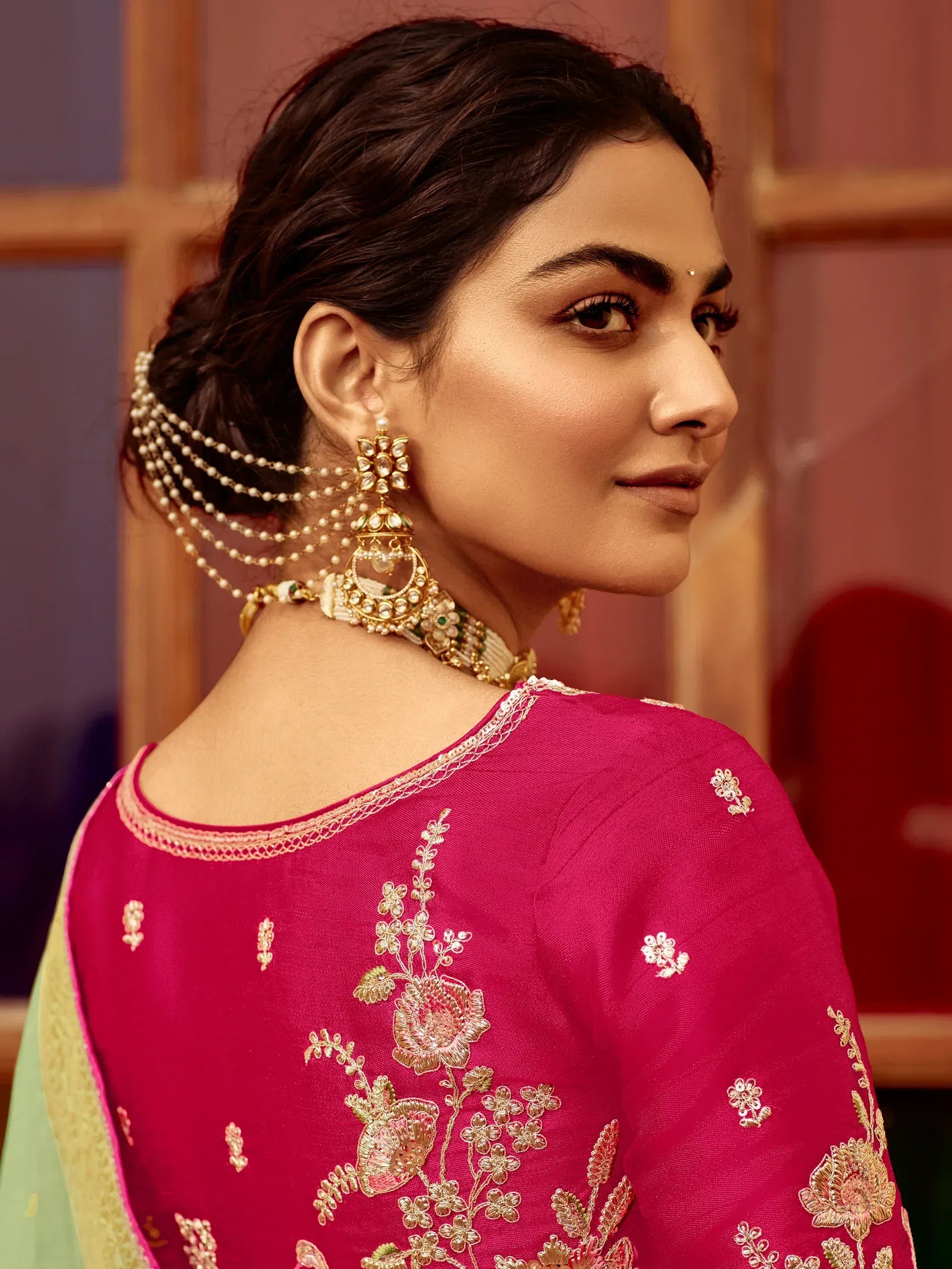 Elegant pink embroidered ethnic wear with gold jewelry and floral detailing