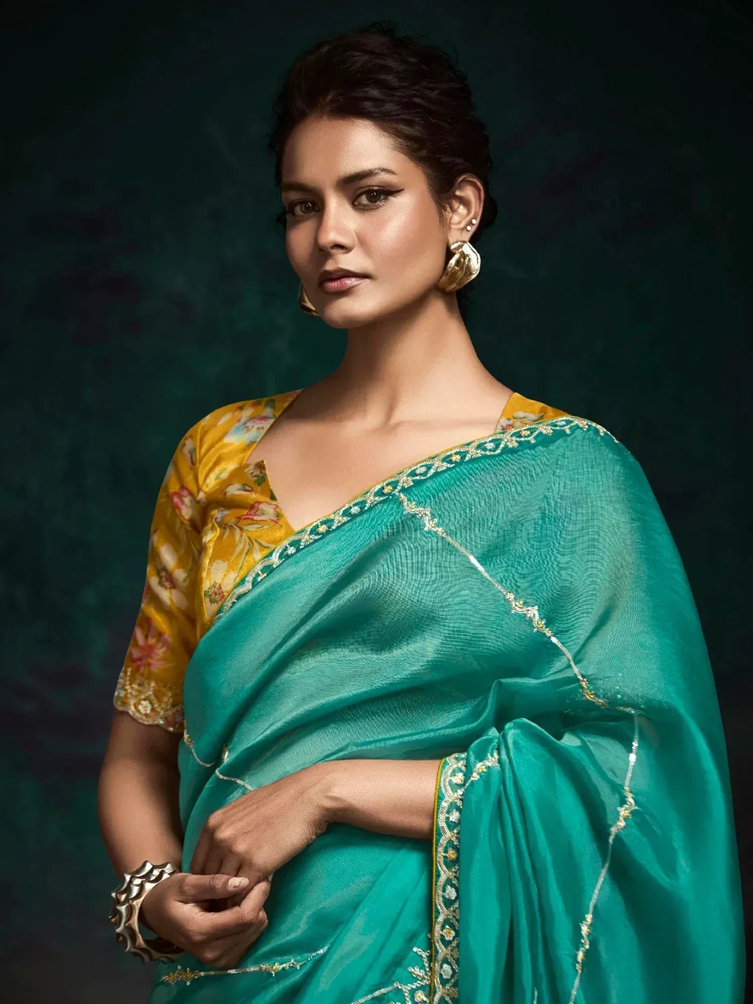 Teal saree with gold embroidery paired with floral yellow blouse, elegant Indian ethnic wear