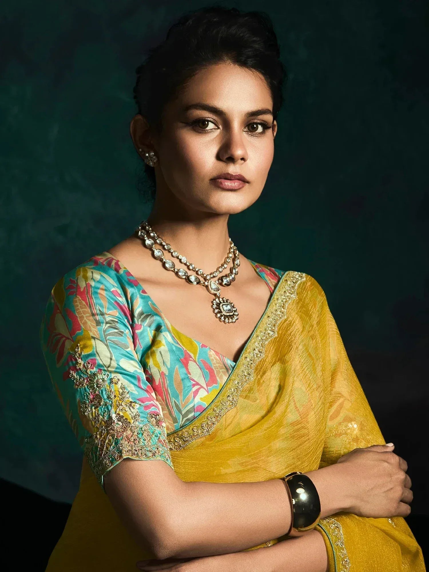 Woman in vibrant yellow saree with floral blouse, traditional Indian ethnic wear, designer jewelry