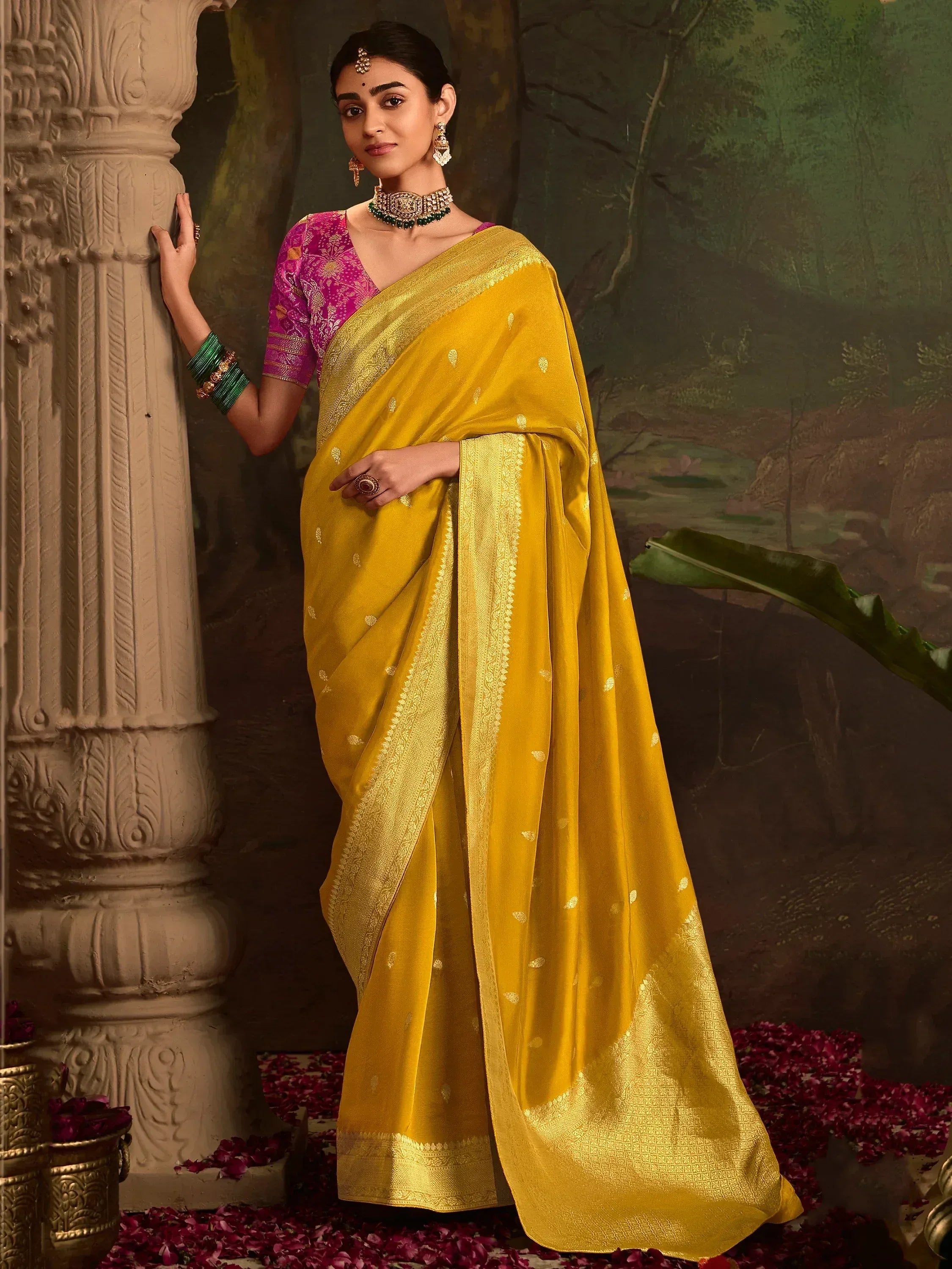 Yellow silk saree with gold zari border and pink blouse, styled with traditional jewelry for Indian ethnic wear