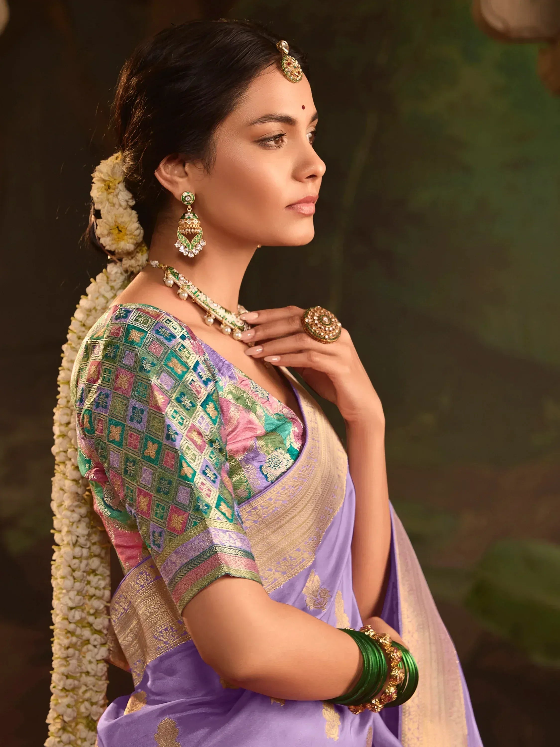 Elegant woman in purple silk saree with gold zari, colorful blouse, and traditional jewelry for Indian ethnic wear.