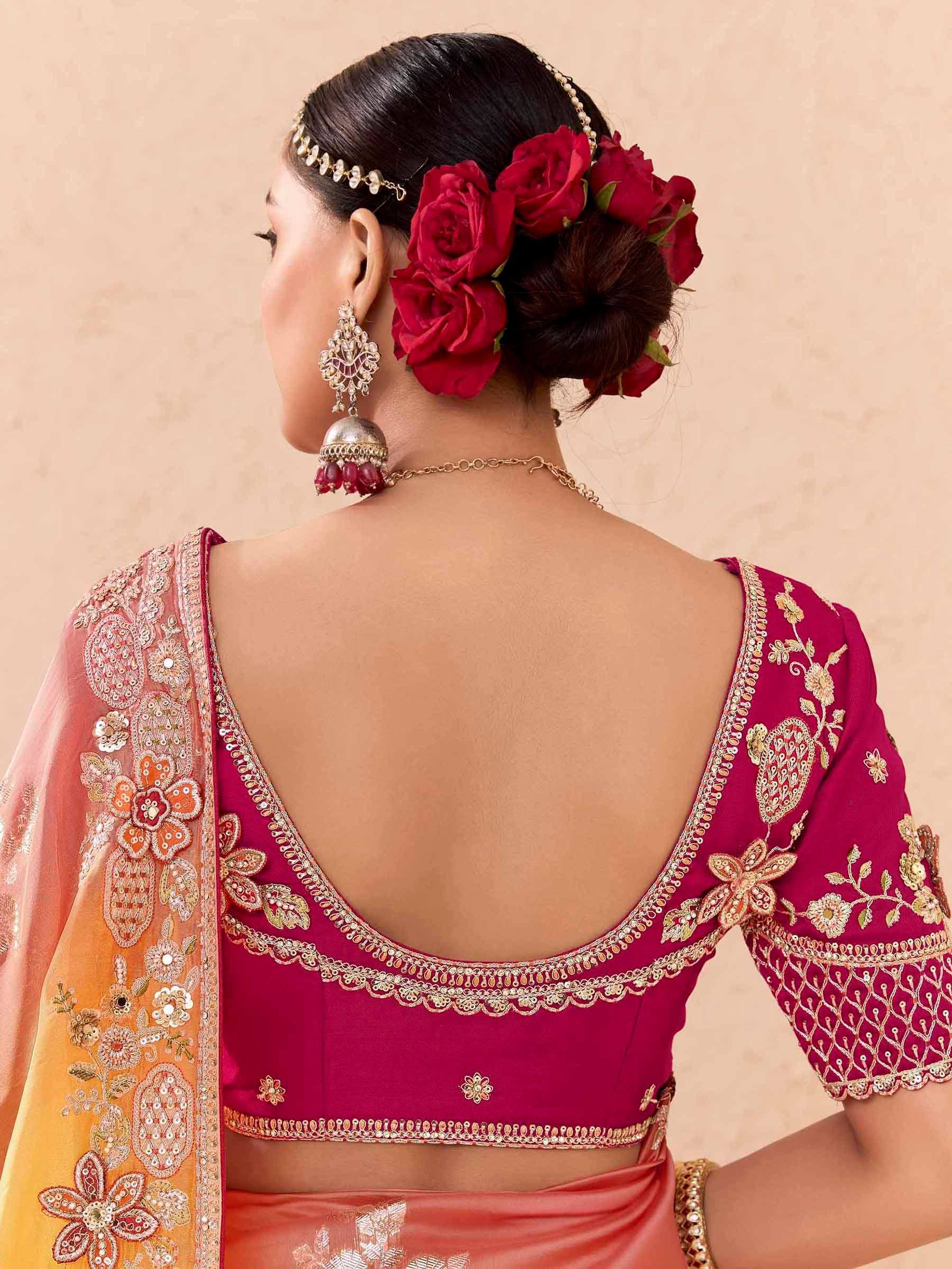 Back view of woman in maroon embroidered lehenga choli with floral dupatta, red rose hair accessory, and jhumka earrings