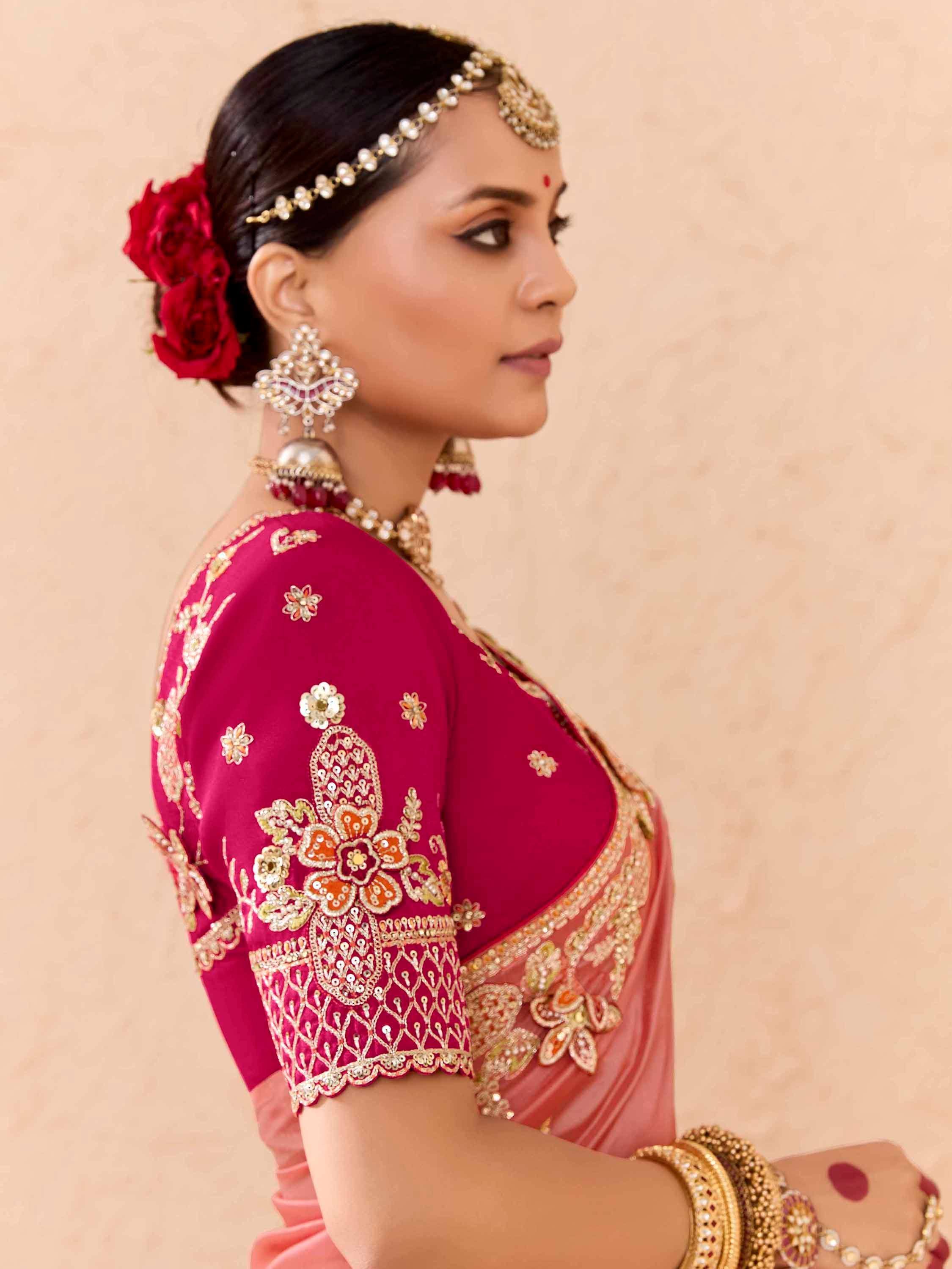 Woman in elegant Indian saree with gold embroidery, floral hair accessory, and traditional jewelry