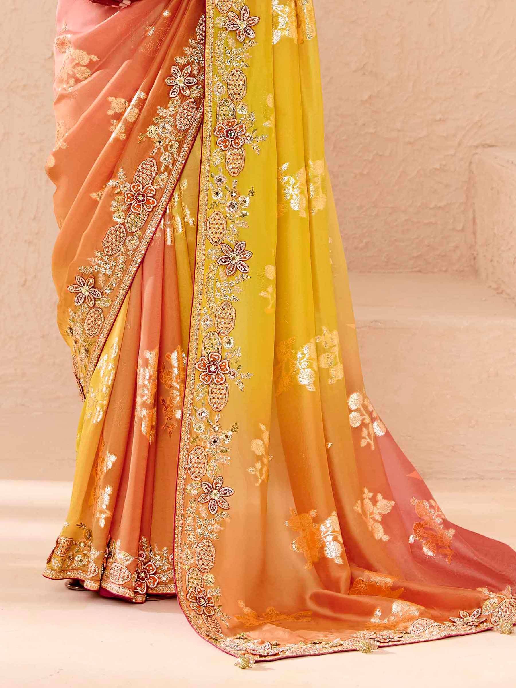 Elegant peach and mustard Indian saree with floral embroidery and golden zari work, perfect for festive occasions.